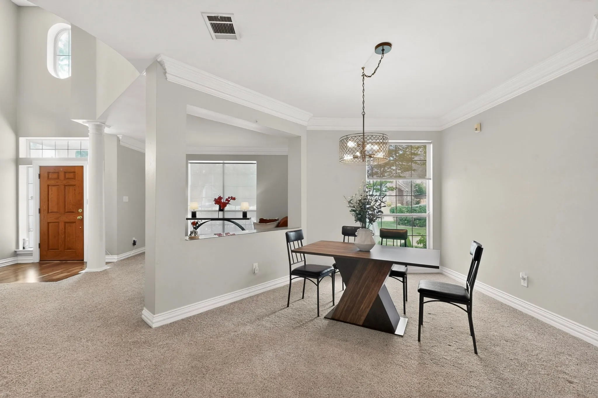 Dining area with broad window and contemporary chandelier