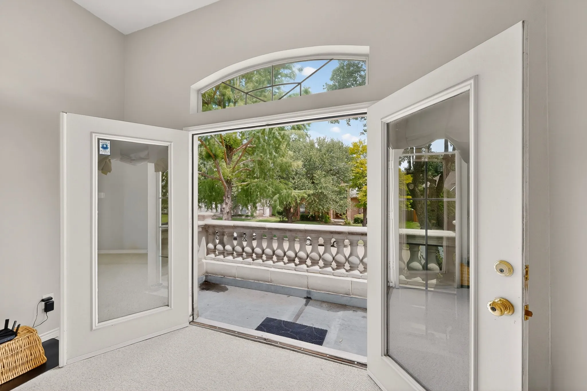 French doors opening to an exterior balcony featuring a decorative balustrade