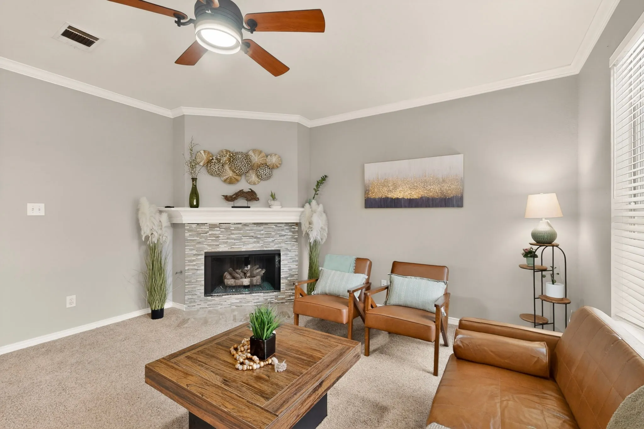 Living area featuring a corner fireplace with a stacked stone facade and white mantel