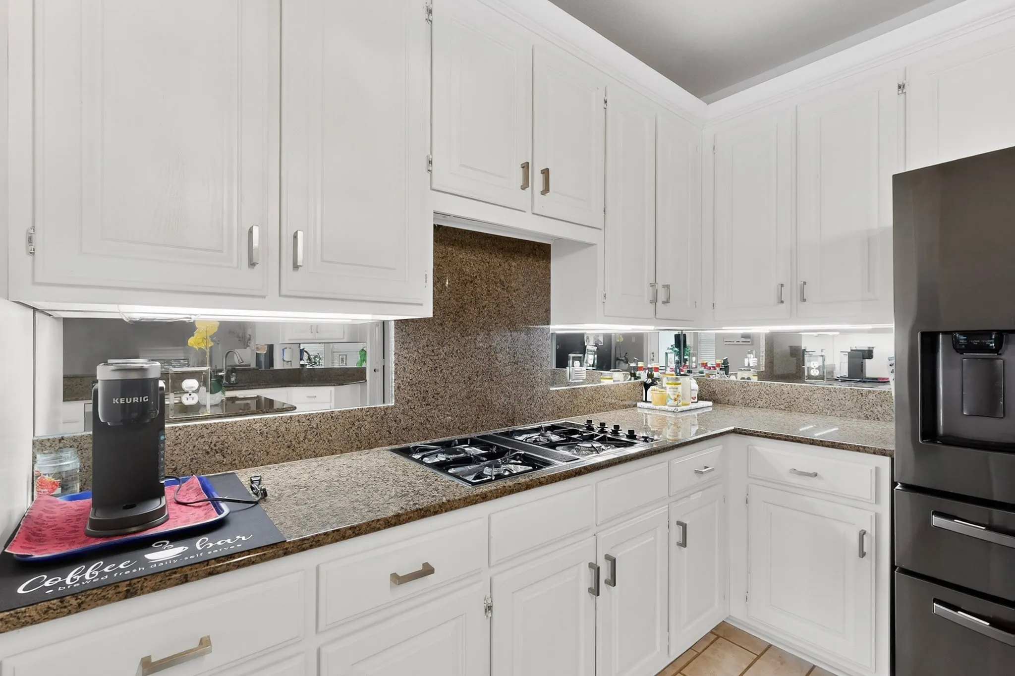 Kitchen featuring white cabinetry, granite countertops, and a built-in gas cooktop