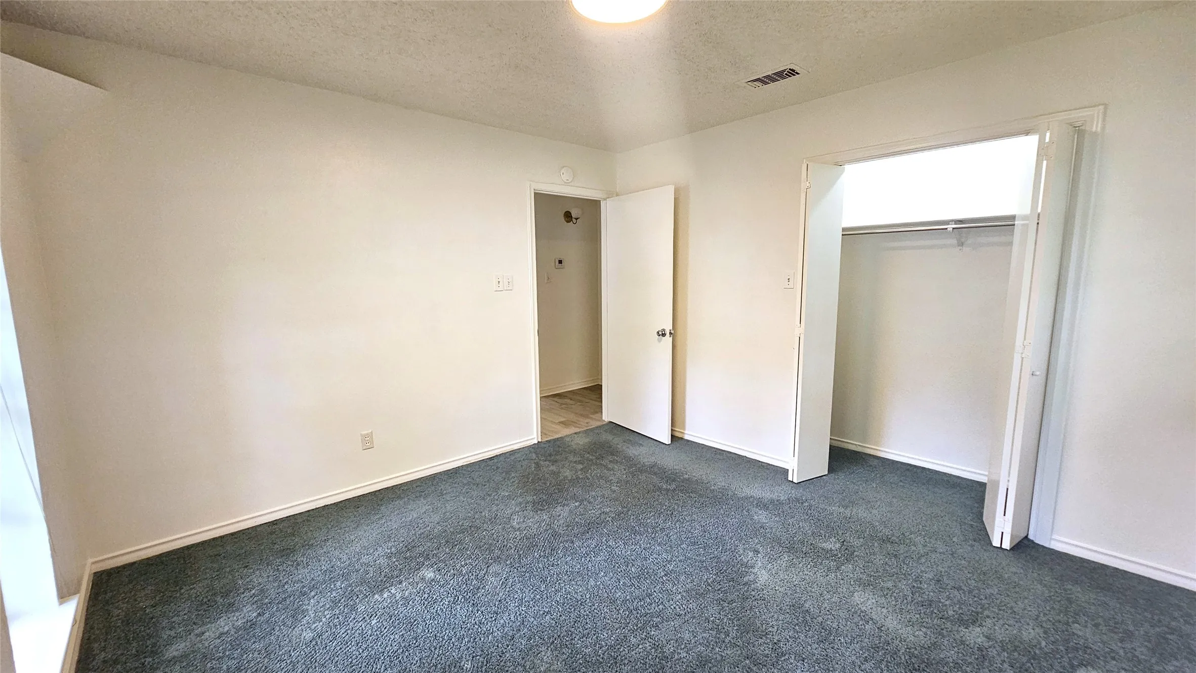 Bedroom 6 with blue carpet, a closet, and hidden corner accent lighting.
