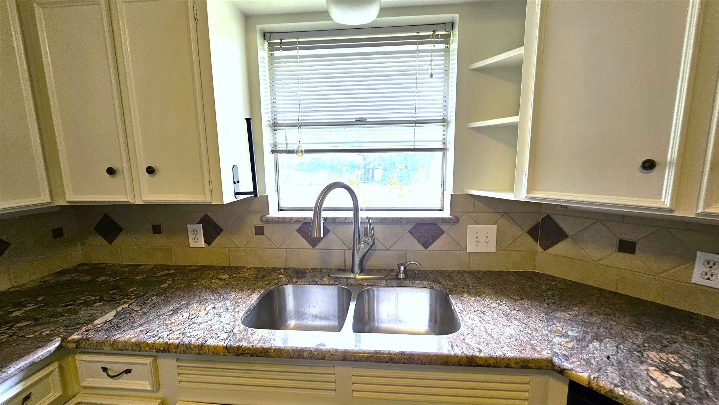 Kitchen featuring a sink, tile backsplash, Granite counters, Delta Gooseneck faucet in brushed nickel