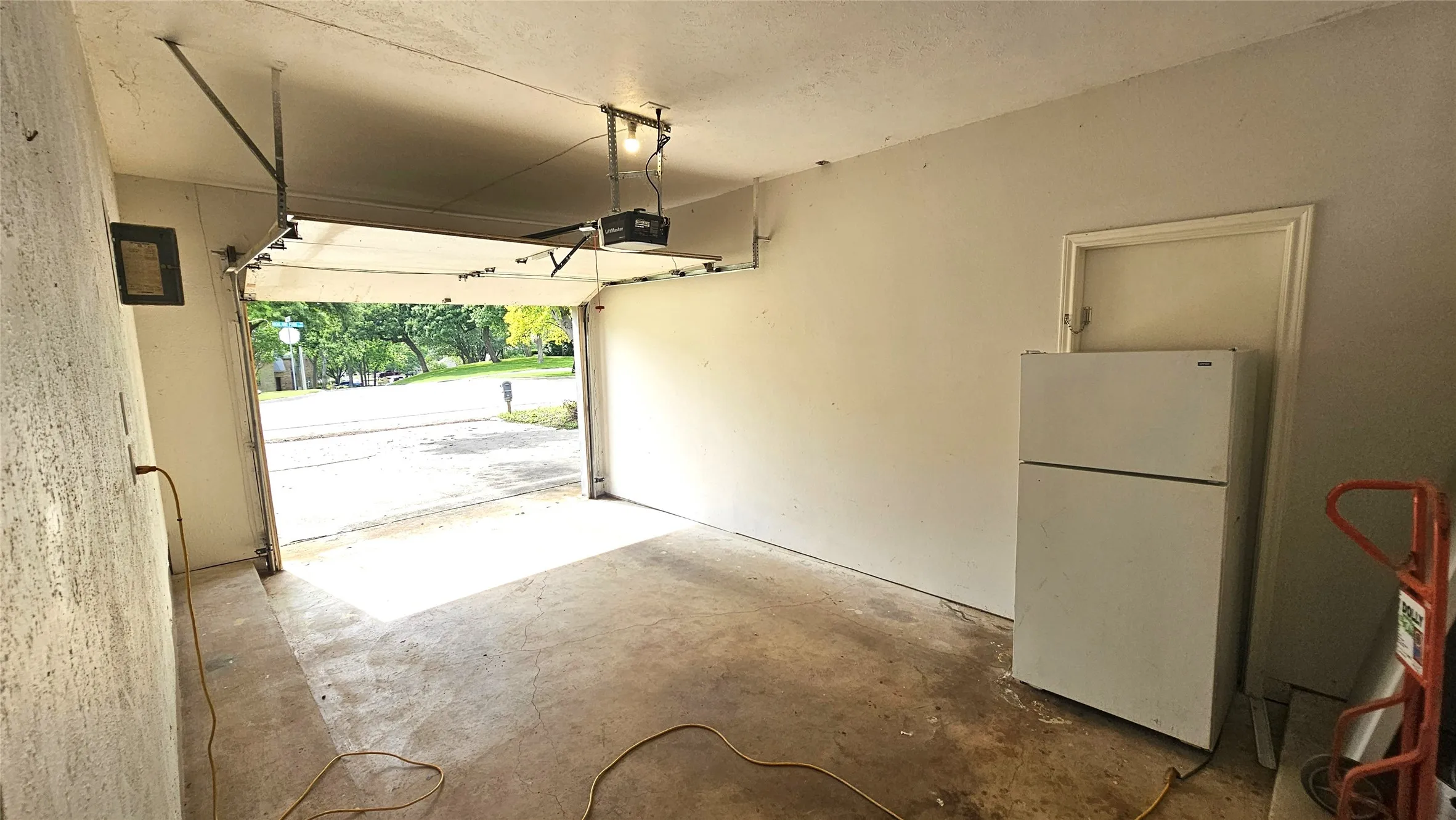 Garage featuring high ceiling and a garage door opener