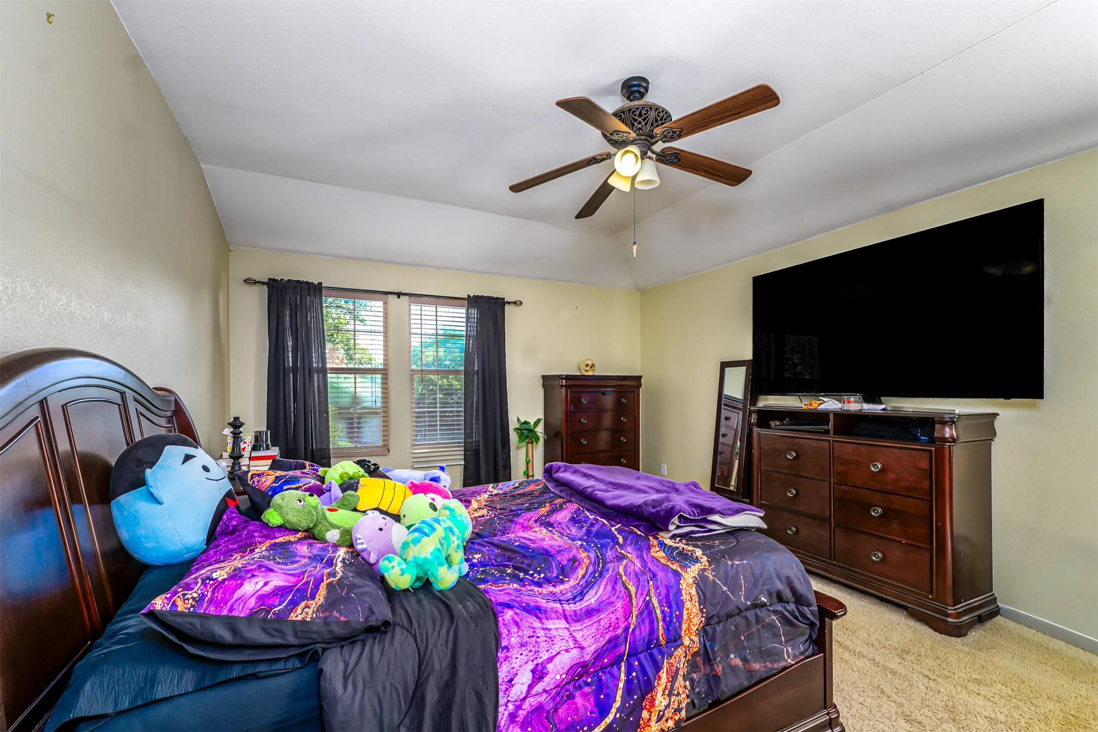 Bedroom with vaulted ceiling and a ceiling fan