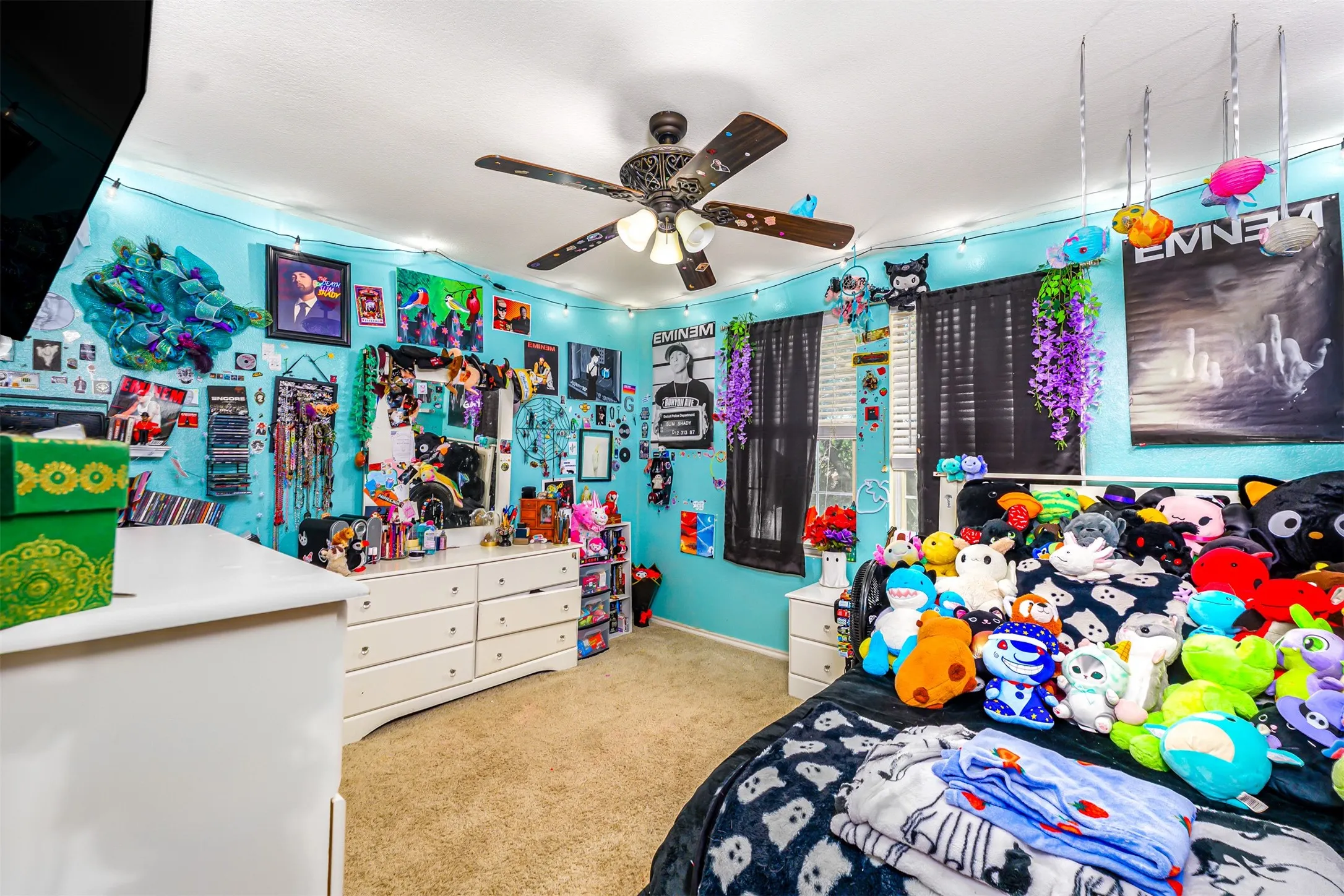 Carpeted bedroom featuring light blue walls and a ceiling fan with integrated lighting