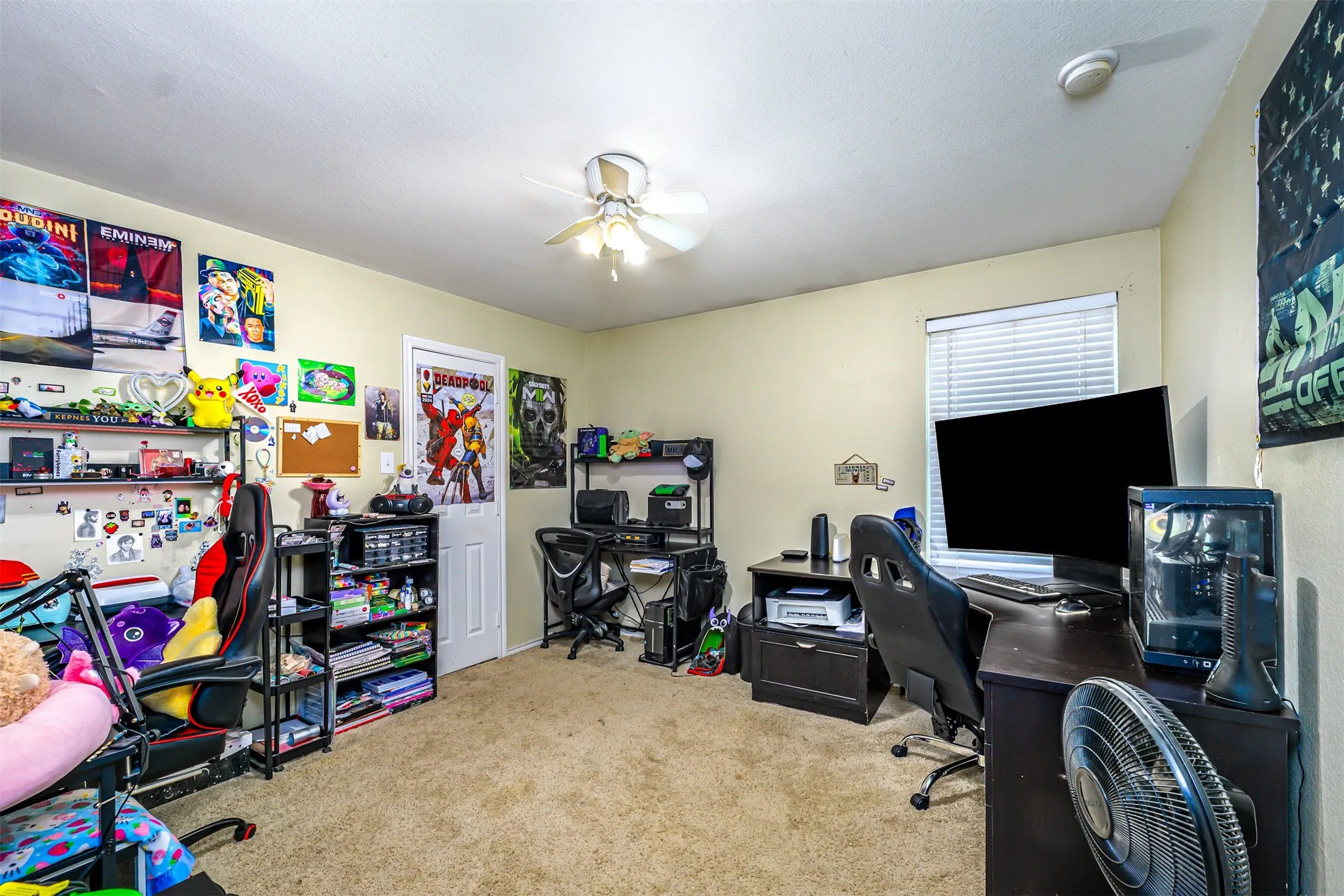 Carpeted room with a ceiling fan, a window with blinds, and light-colored walls