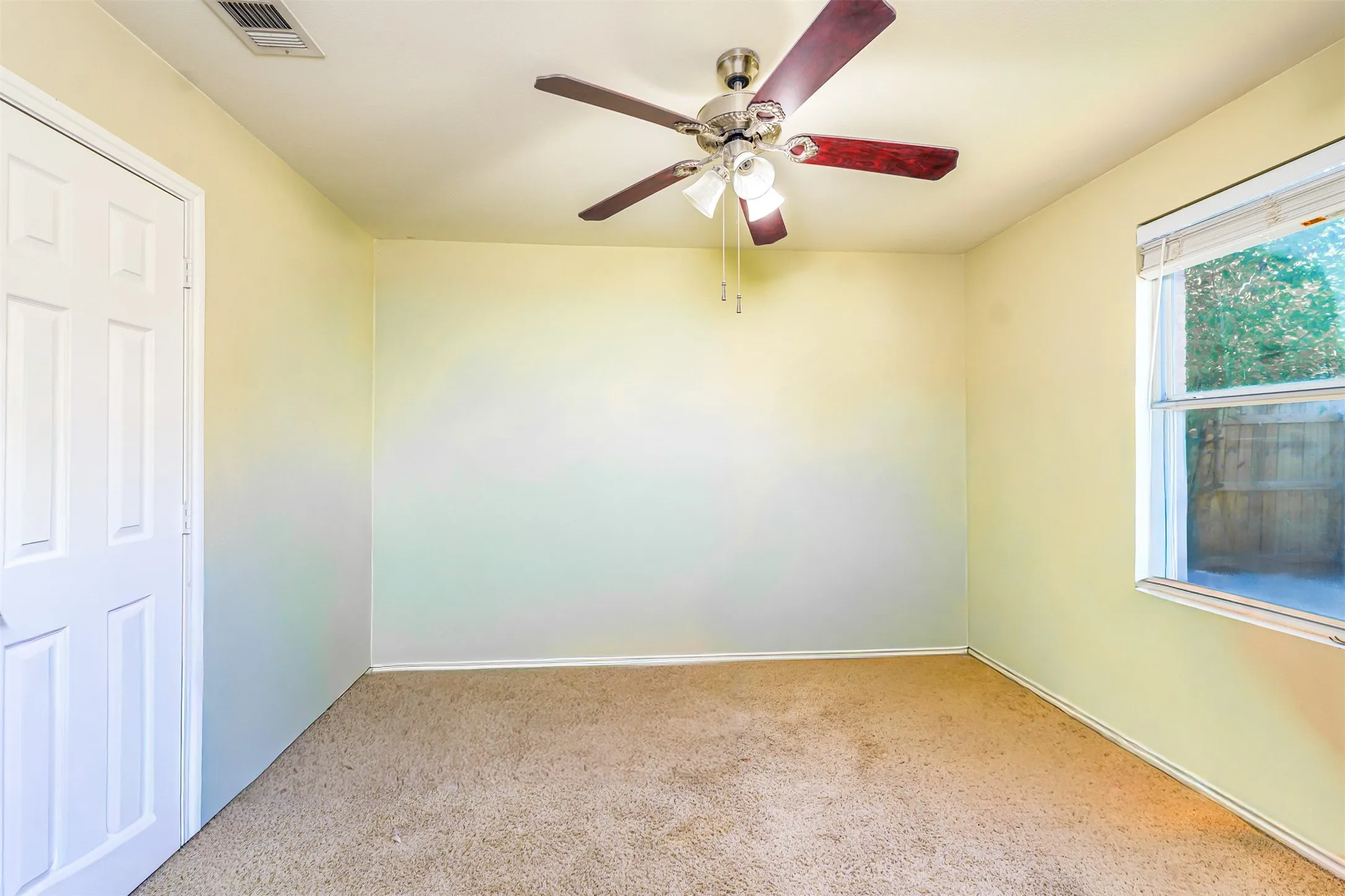 A large bedroom with a ceiling fan