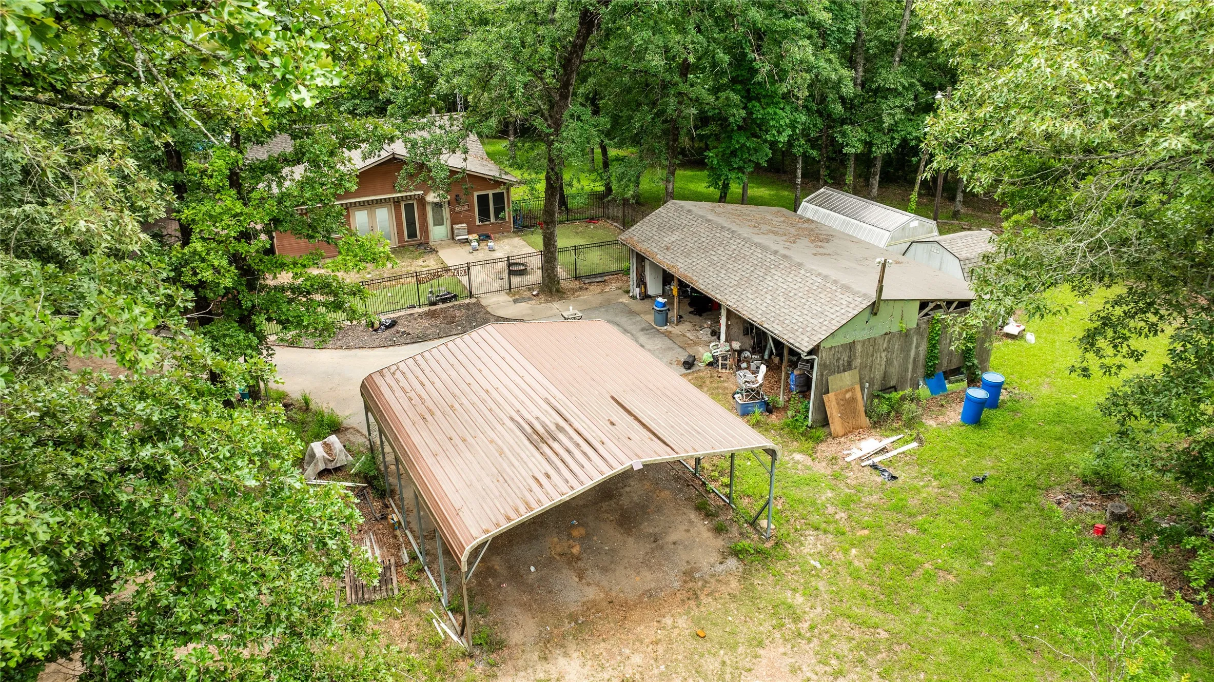 Residential structure with wood siding, a gravel driveway, and a fenced yard