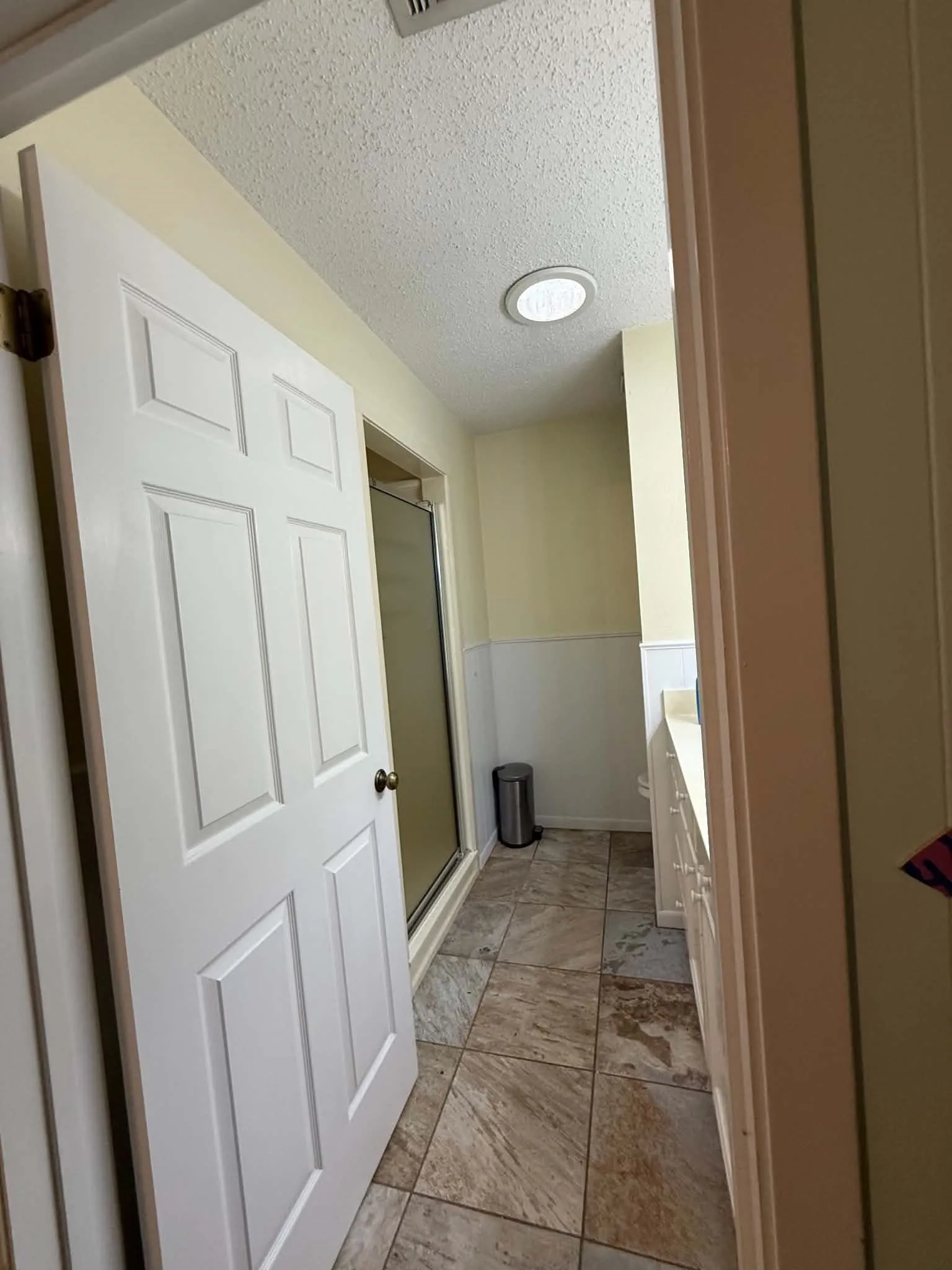 Bathroom featuring tile flooring, wainscoting, and a single vanity with a solid surface countertop