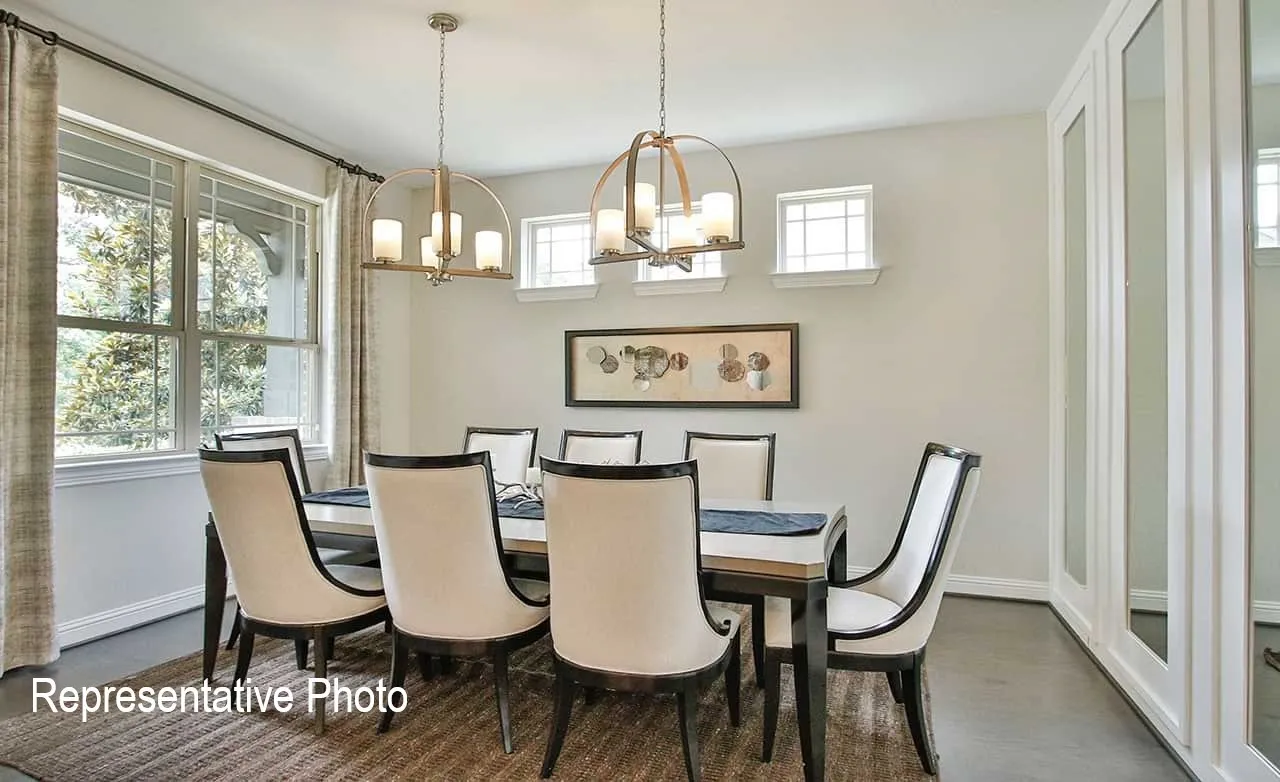 Formal dining room featuring dual pendant lighting fixtures, a large multi-pane window, and wood-finish flooring