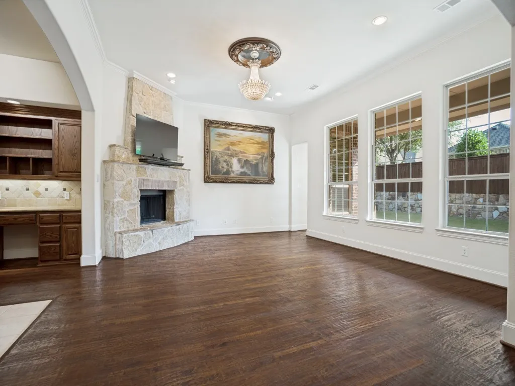     Inviting living room featuring rich wood floors and a stunning floor-to-ceiling stone fireplace.