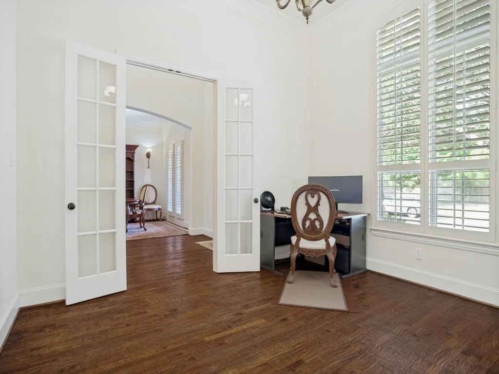     Private study with rich wood floors and views of the front yard.