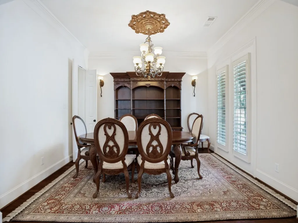     Elegant formal dining room featuring windows with a view of the front porch.