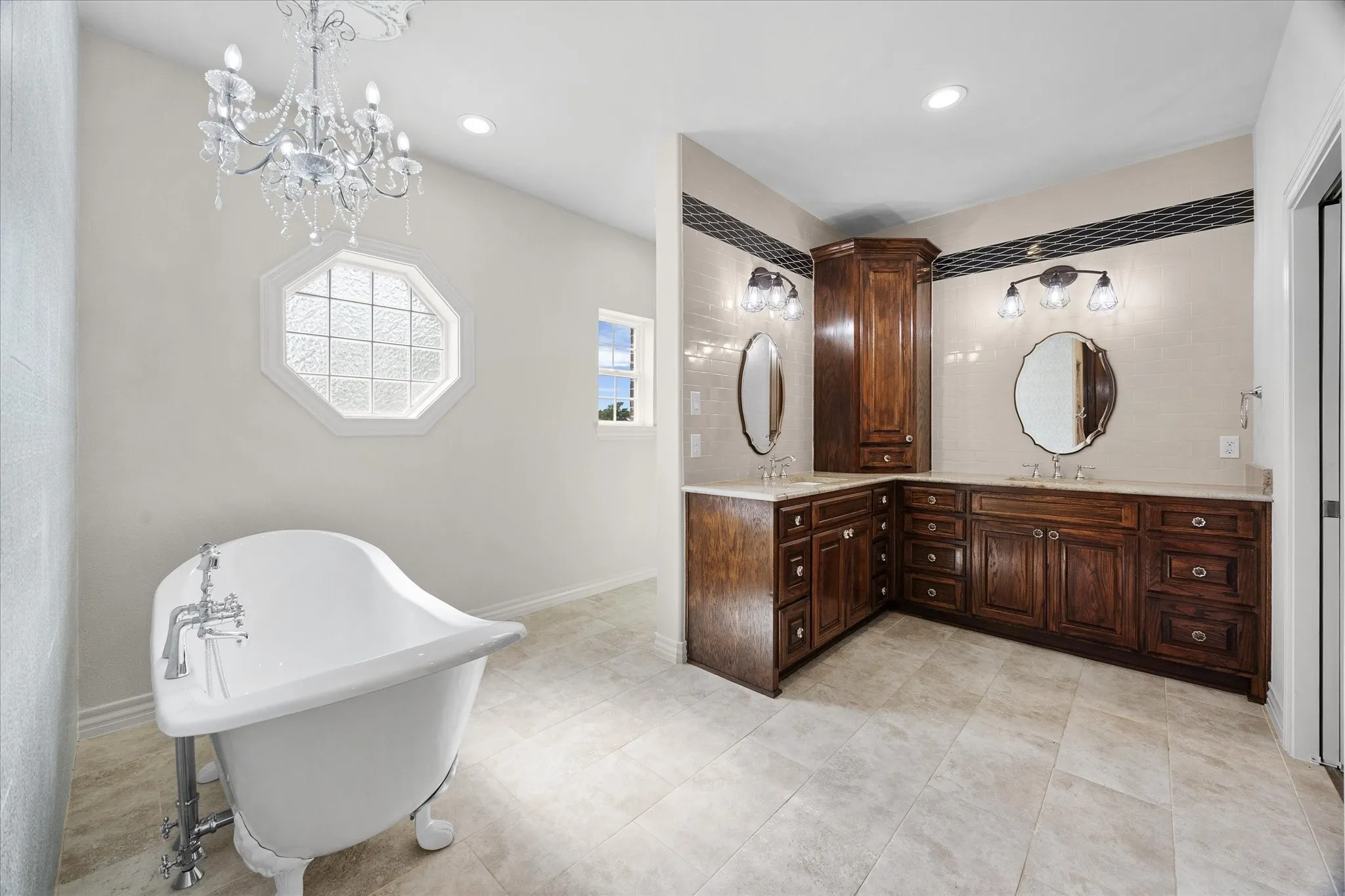 Spa style bath includes soaking tub overlooking his and her vanities