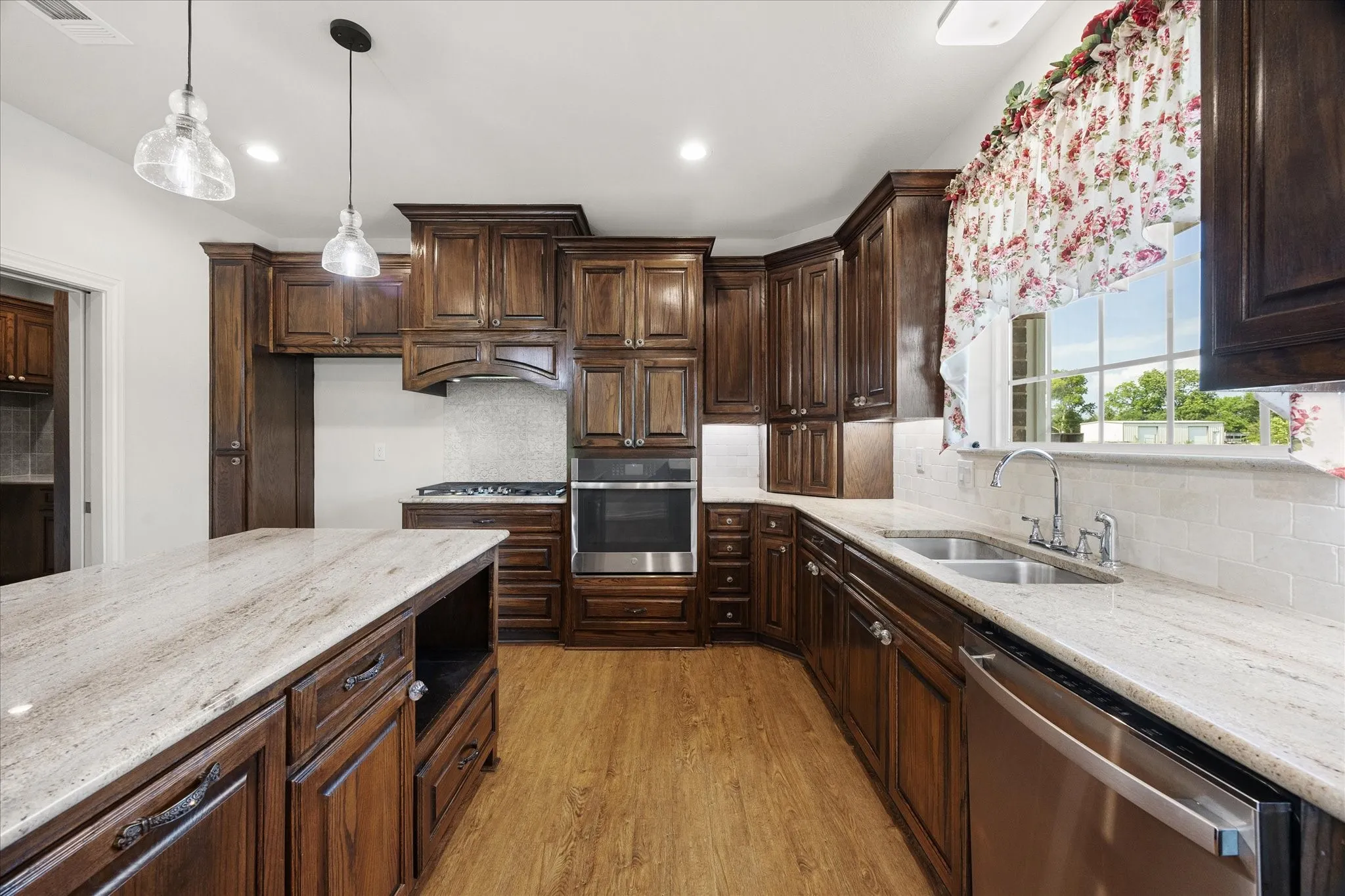 An abundance of solid wood cabinetry, quartz countertops, center island and stainless steel appliances are among this home's many amenities