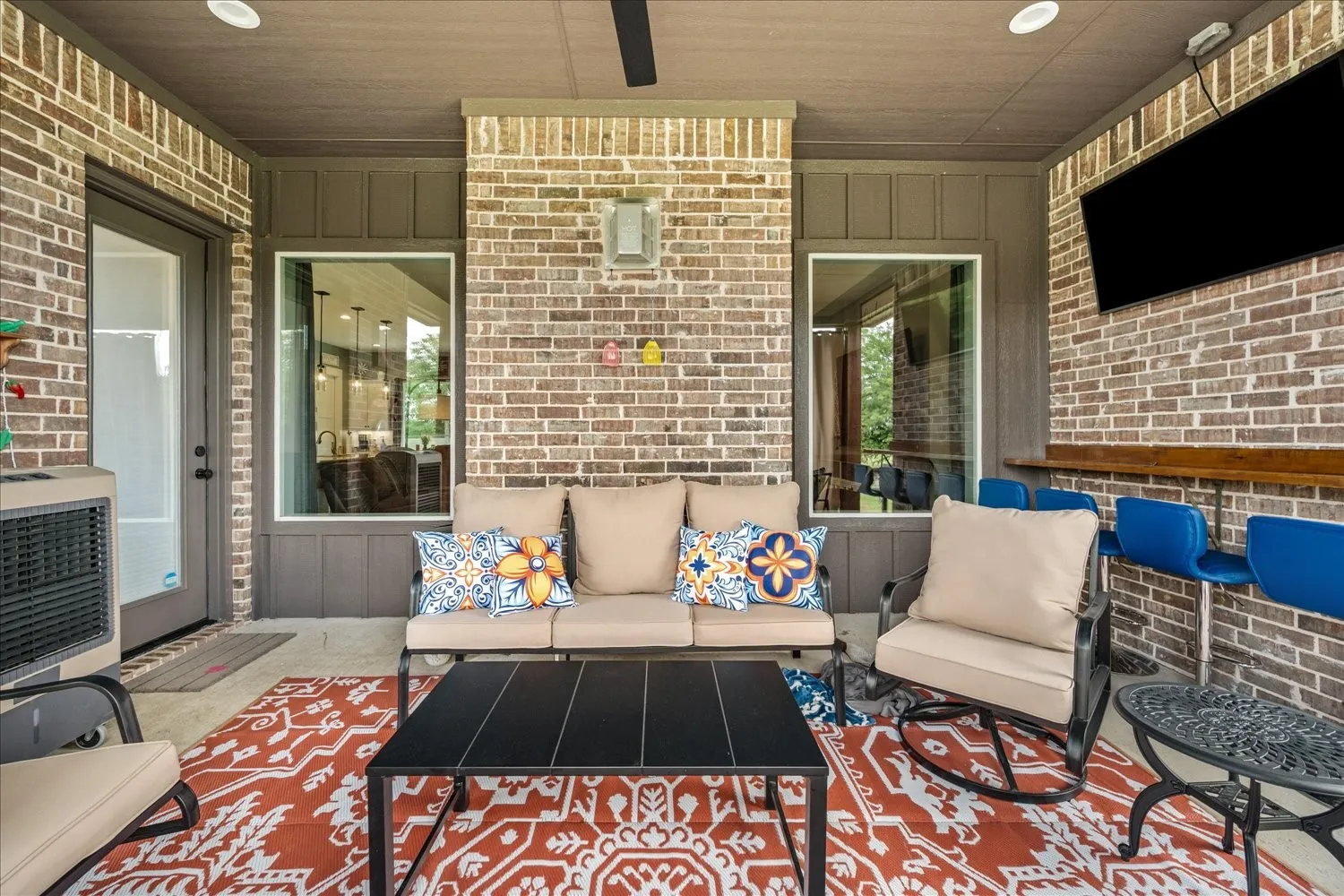 Covered patio featuring brick and board and batten siding