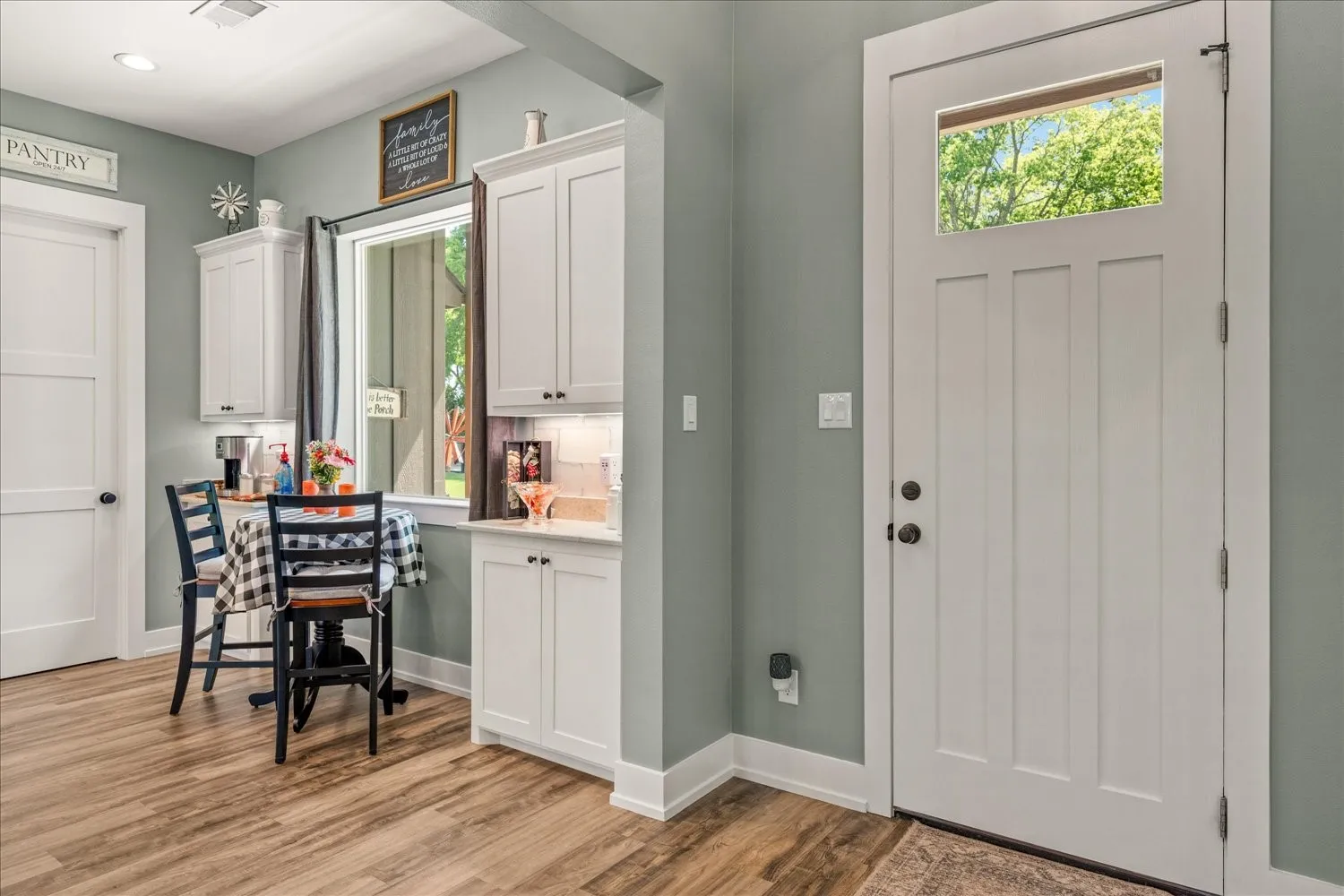 Craftsman-style entry door with upper window, complemented by wood-finish flooring