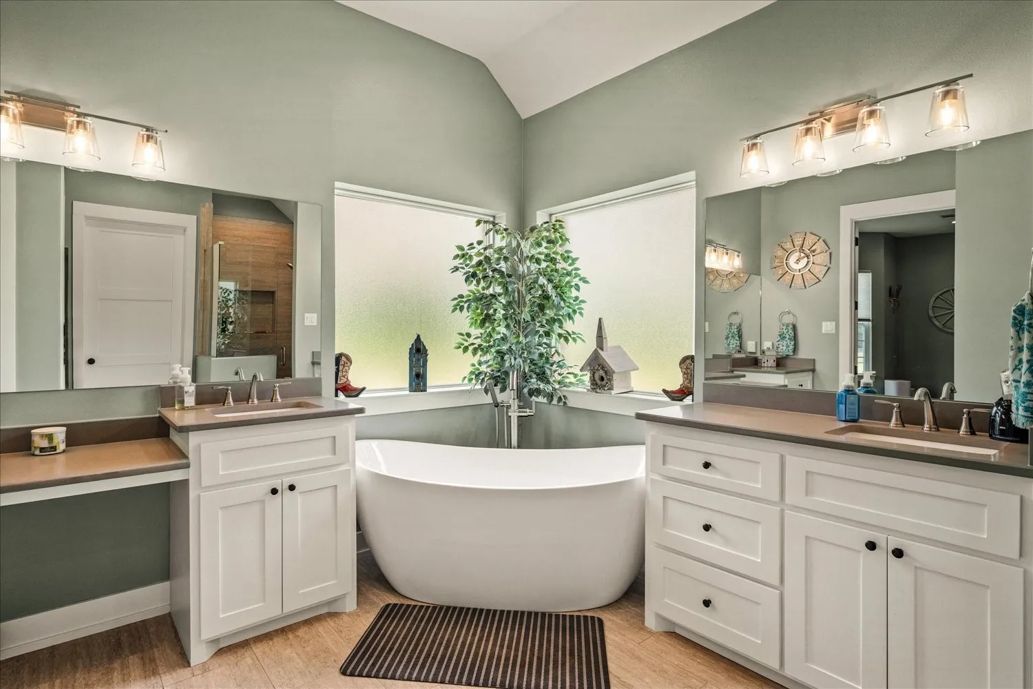 Freestanding soaking tub centered under a large privacy window