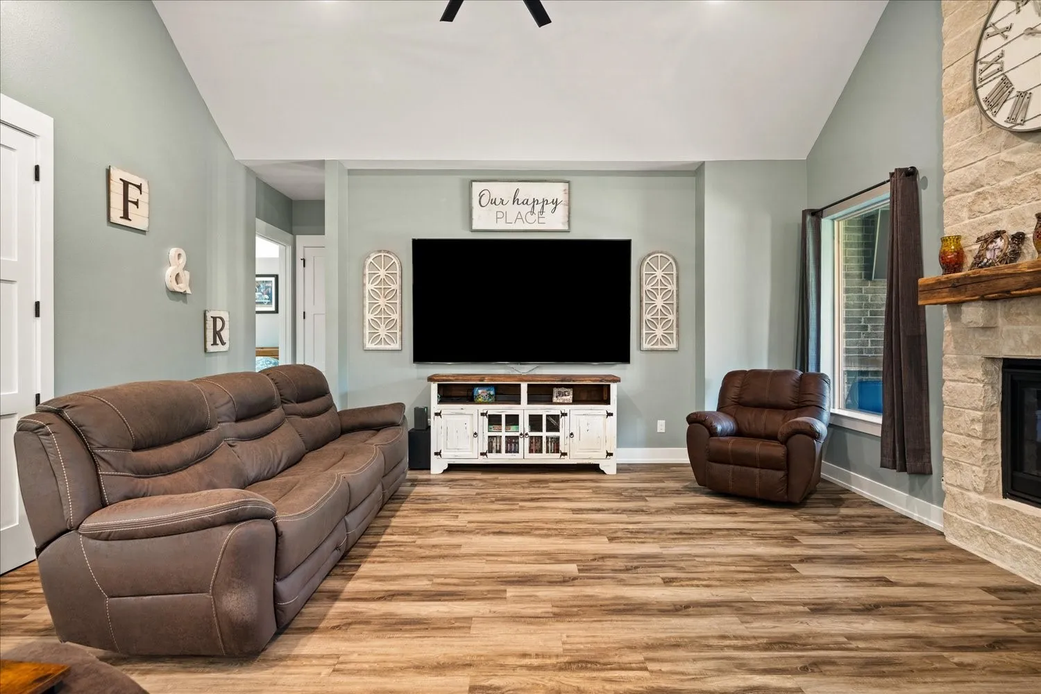 Living area featuring wood-finish flooring and a vaulted ceiling