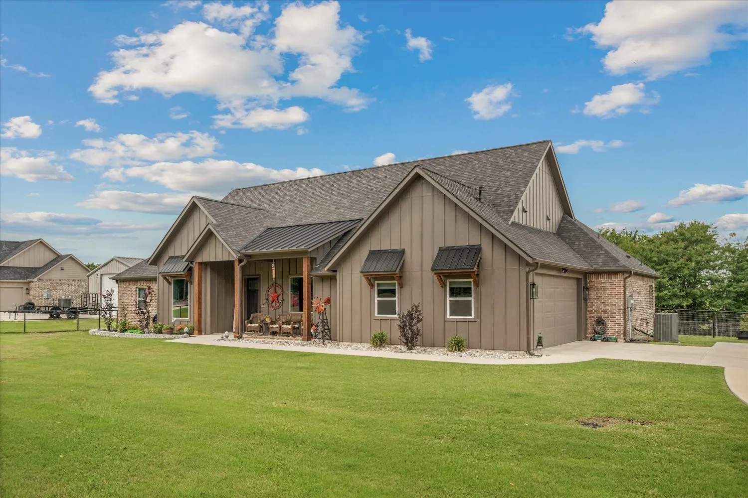 Single-story residence featuring board and batten siding, brick accents, and a shingled roof
