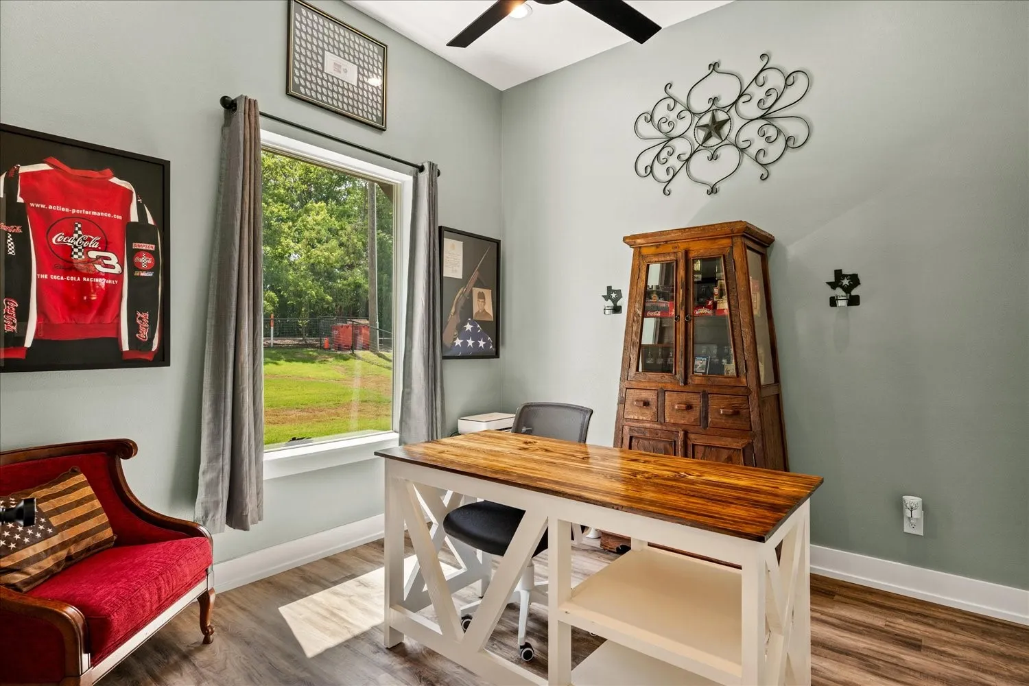 Spacious room featuring wood-finish flooring, a large window offering outdoor scenery, high ceilings, and a ceiling fan