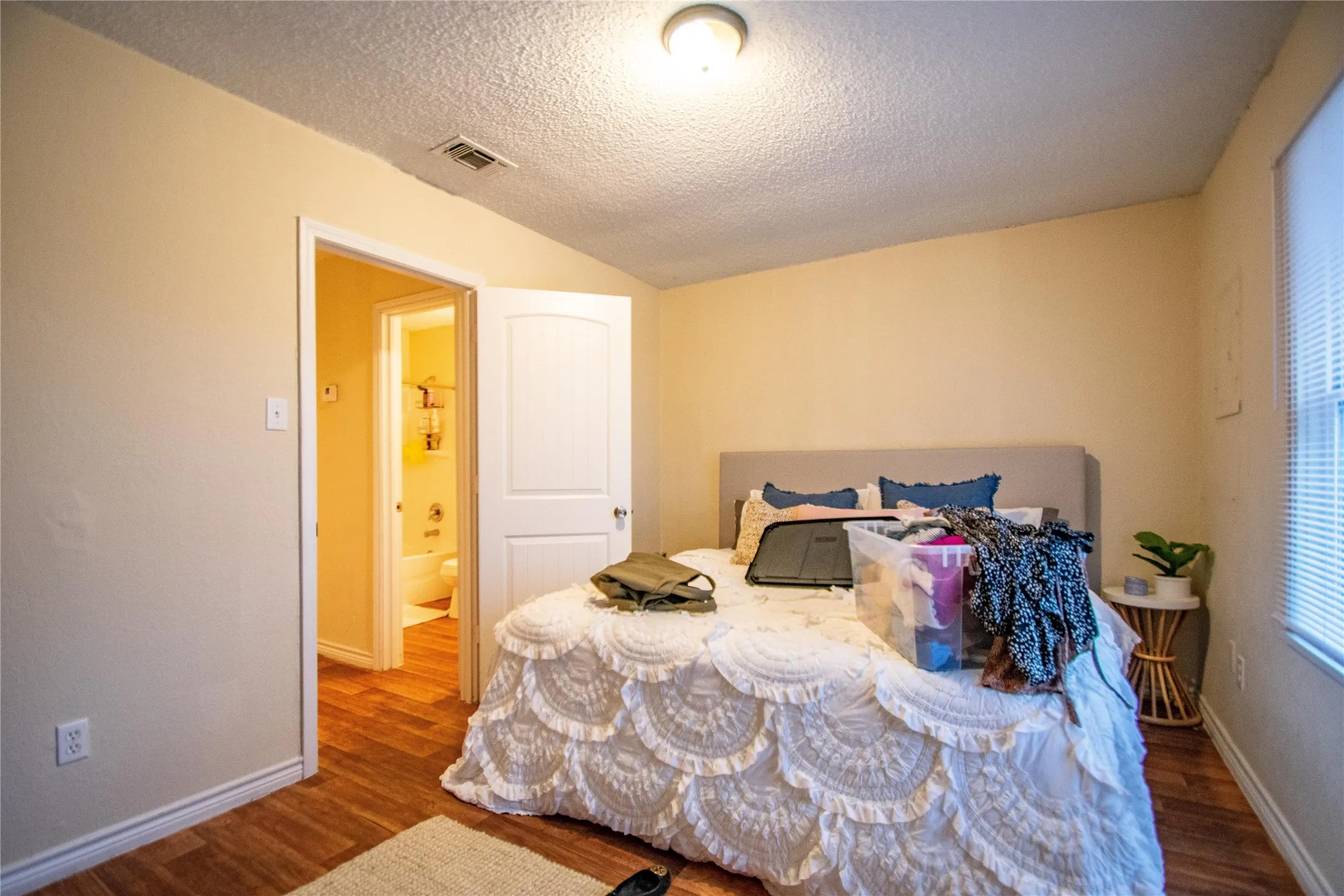 Bedroom with a textured ceiling and dark wood-type flooring
