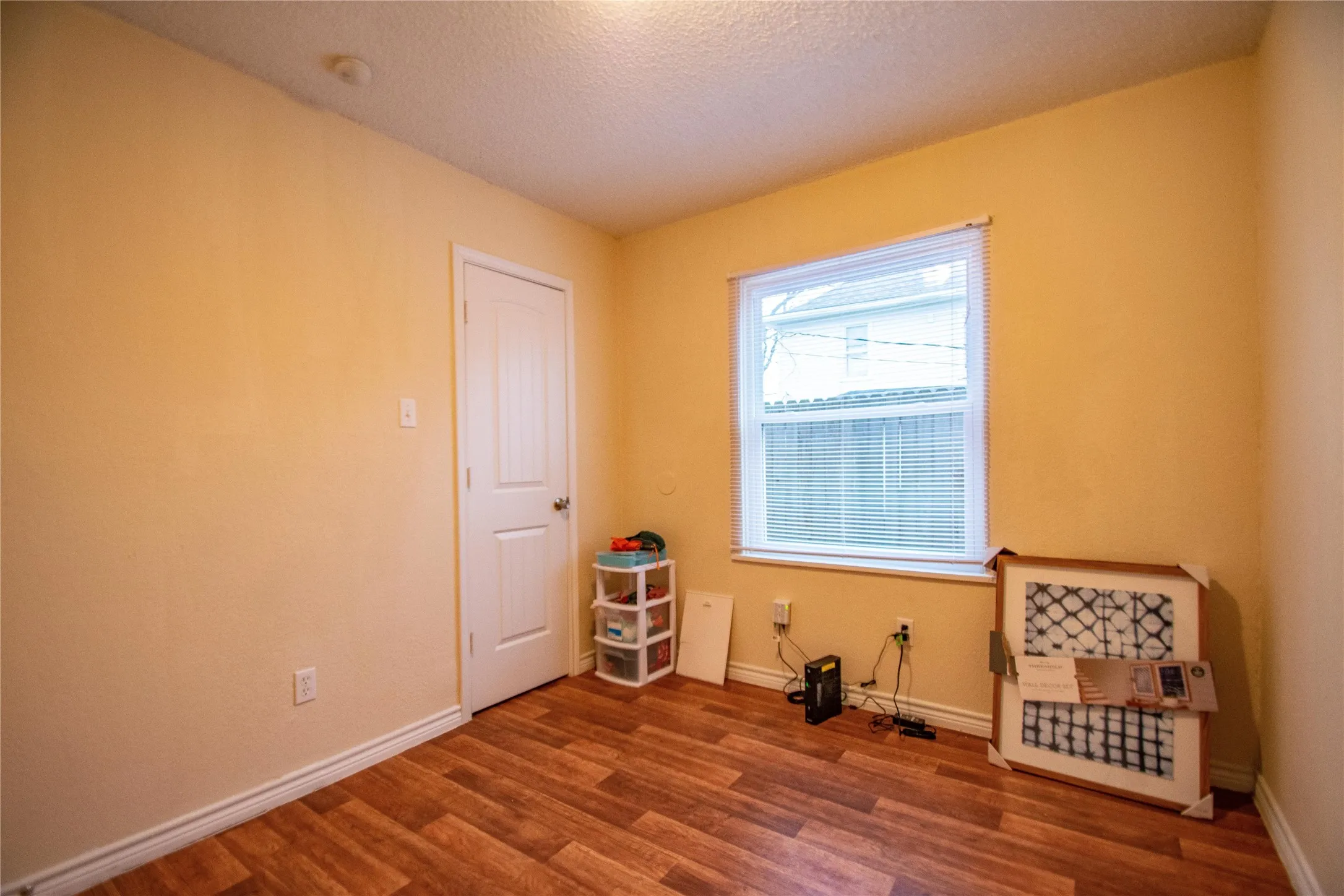 Unfurnished room with dark hardwood / wood-style flooring and a textured ceiling