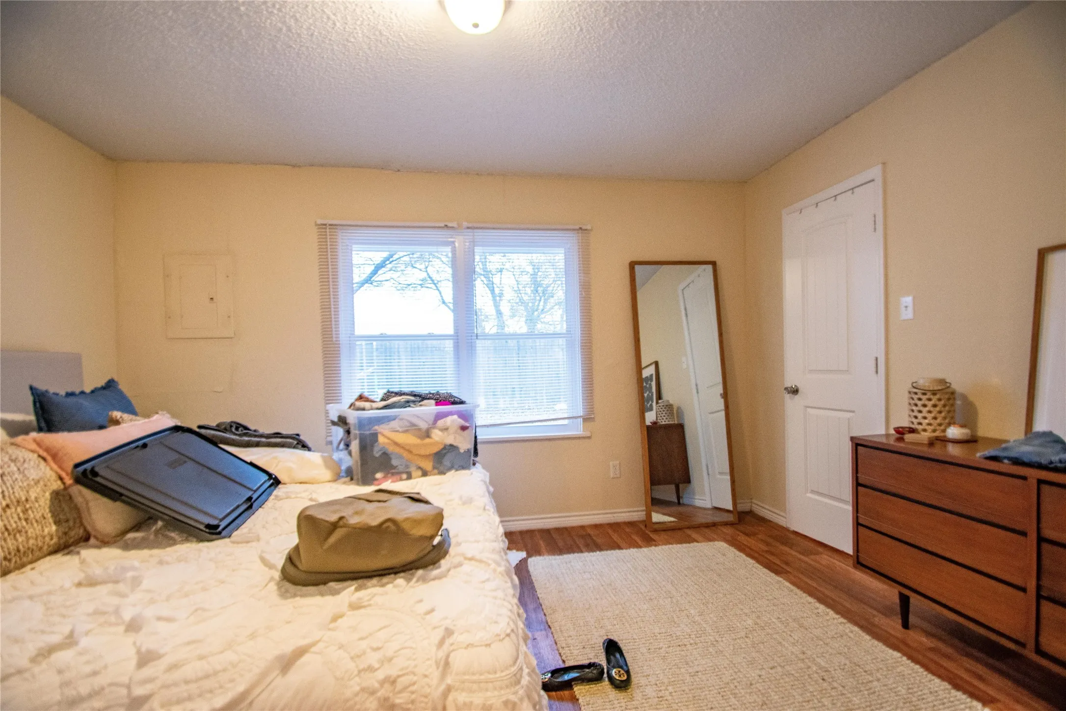Bedroom with dark hardwood / wood-style floors and a textured ceiling
