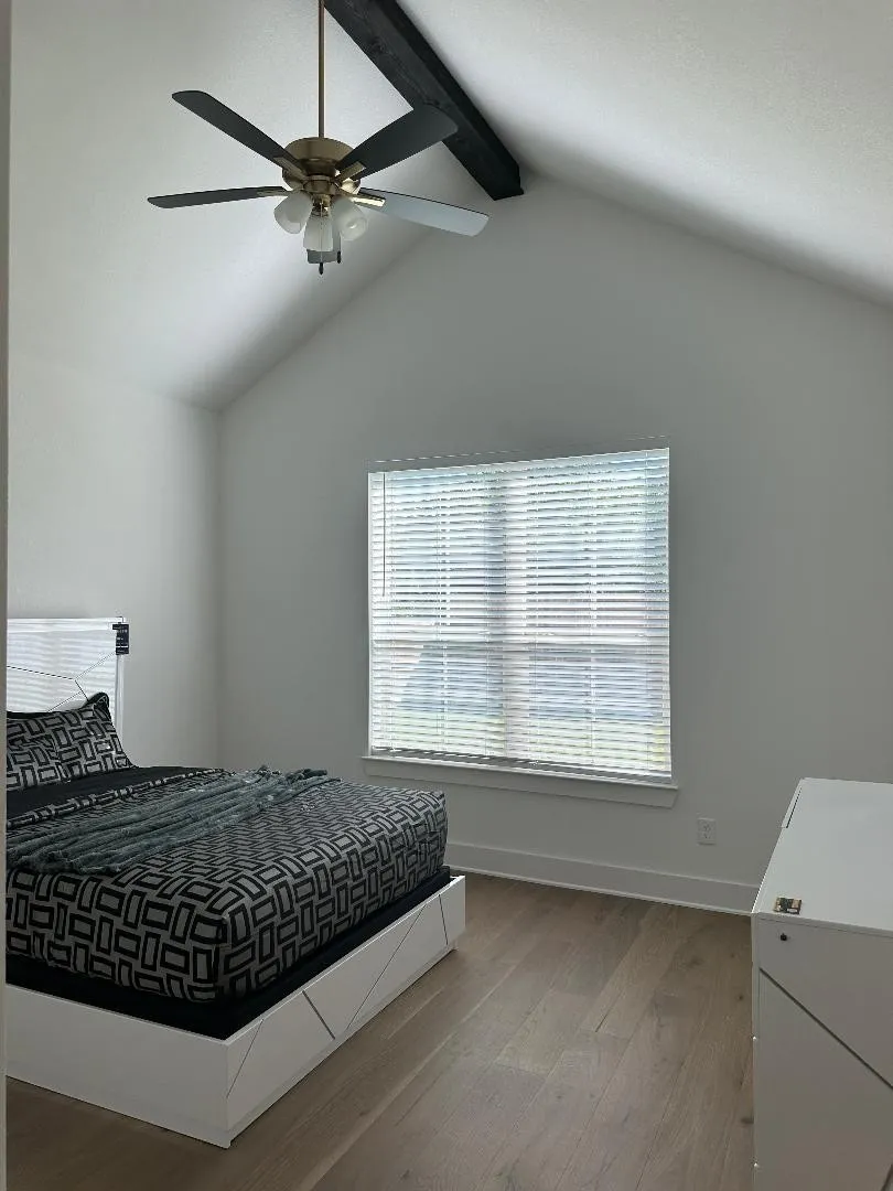 Vaulted ceiling with an exposed beam and ceiling fan