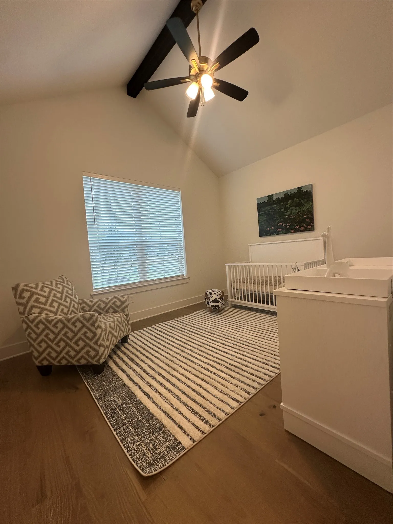Vaulted ceiling featuring an exposed beam and a ceiling fan