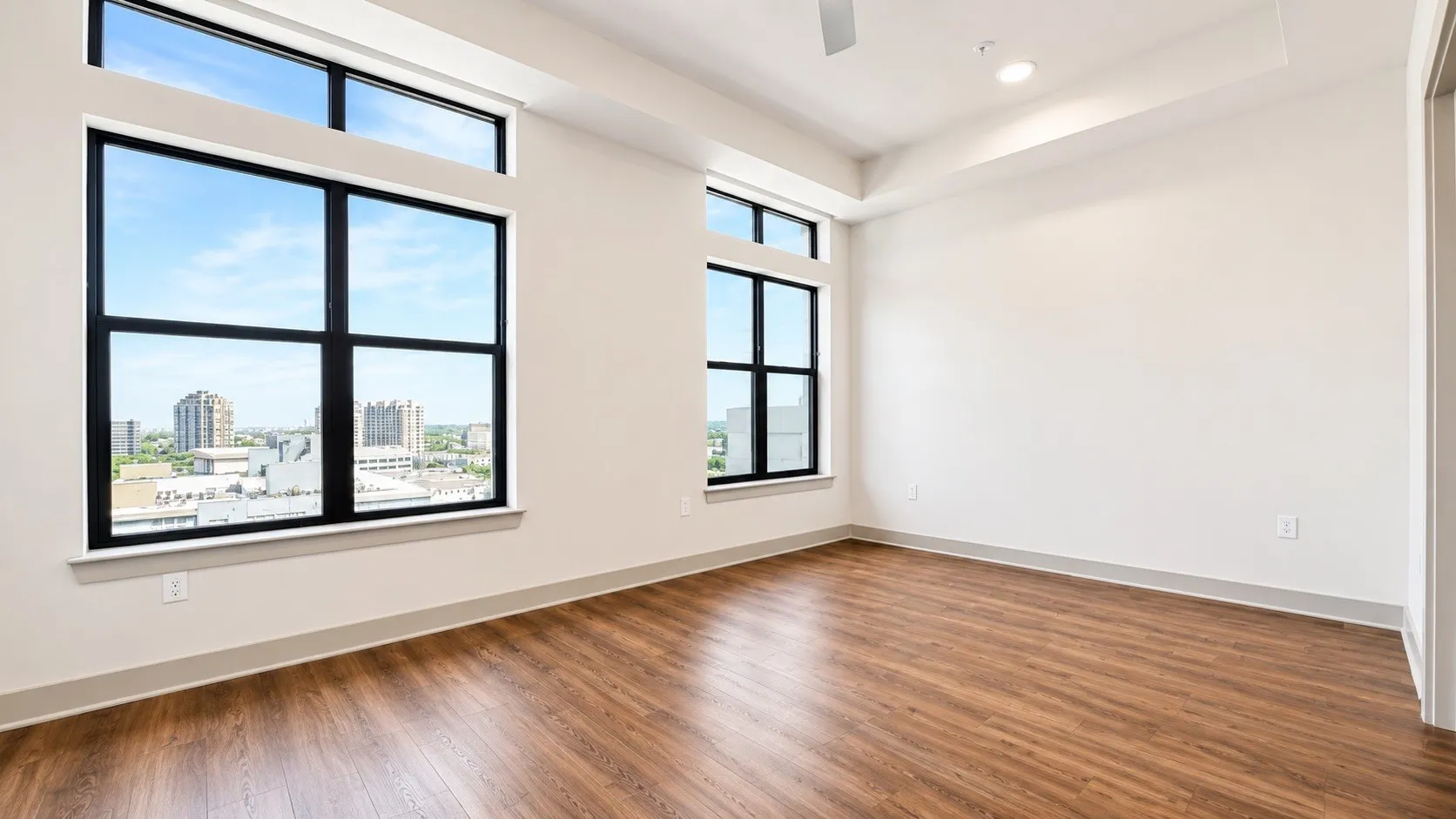 Expansive windows with black framing, wood-finish flooring, recessed lighting, ceiling fan, and high ceilings