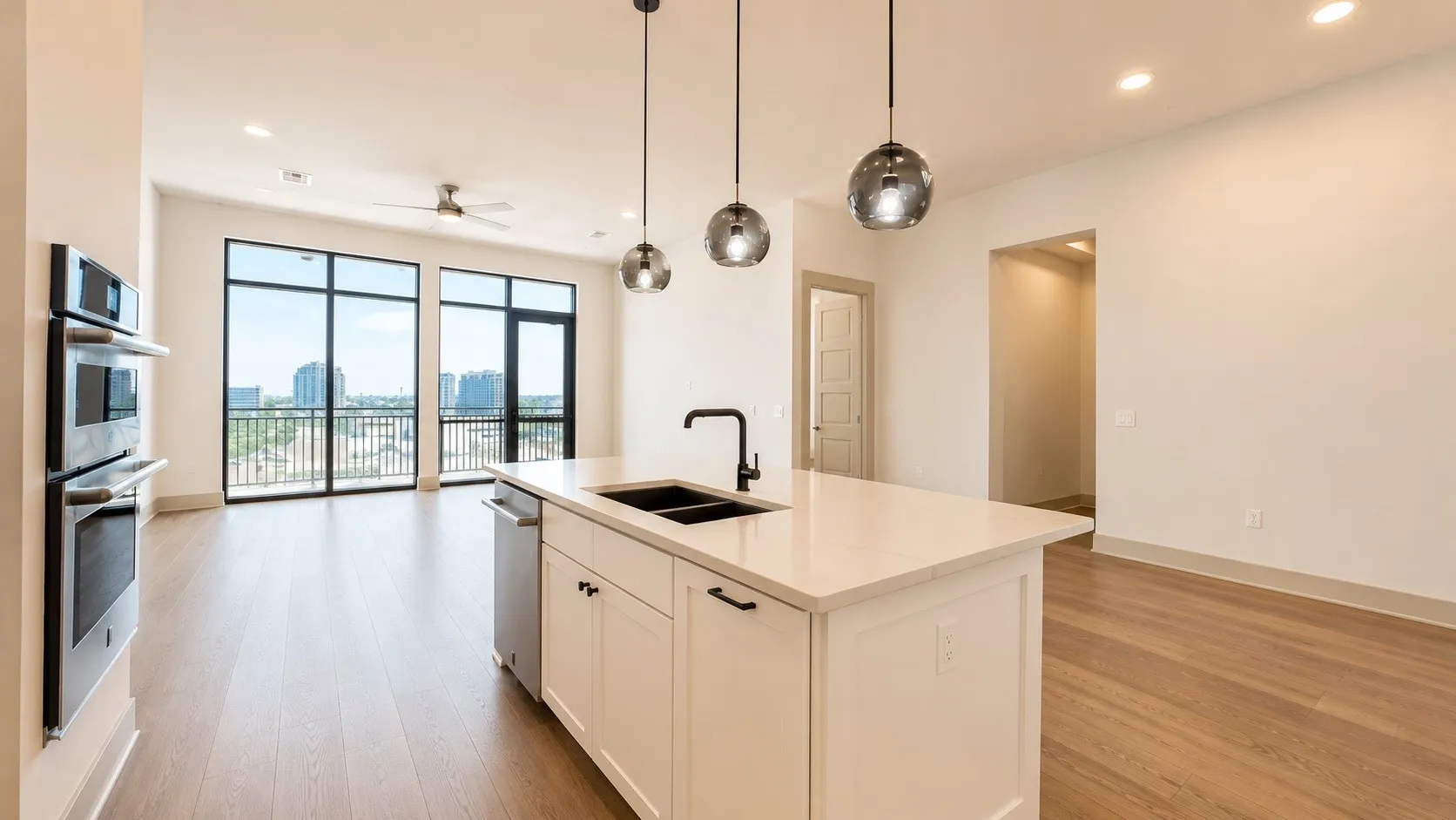 Kitchen island featuring a quartz countertop, integrated sink with matte black faucet, and pendant lighting