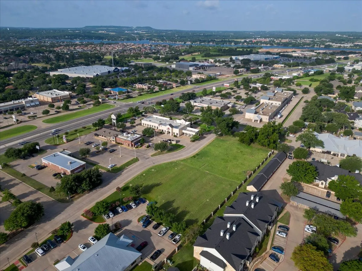 Expansive green space featuring perimeter fencing and a paved access road
