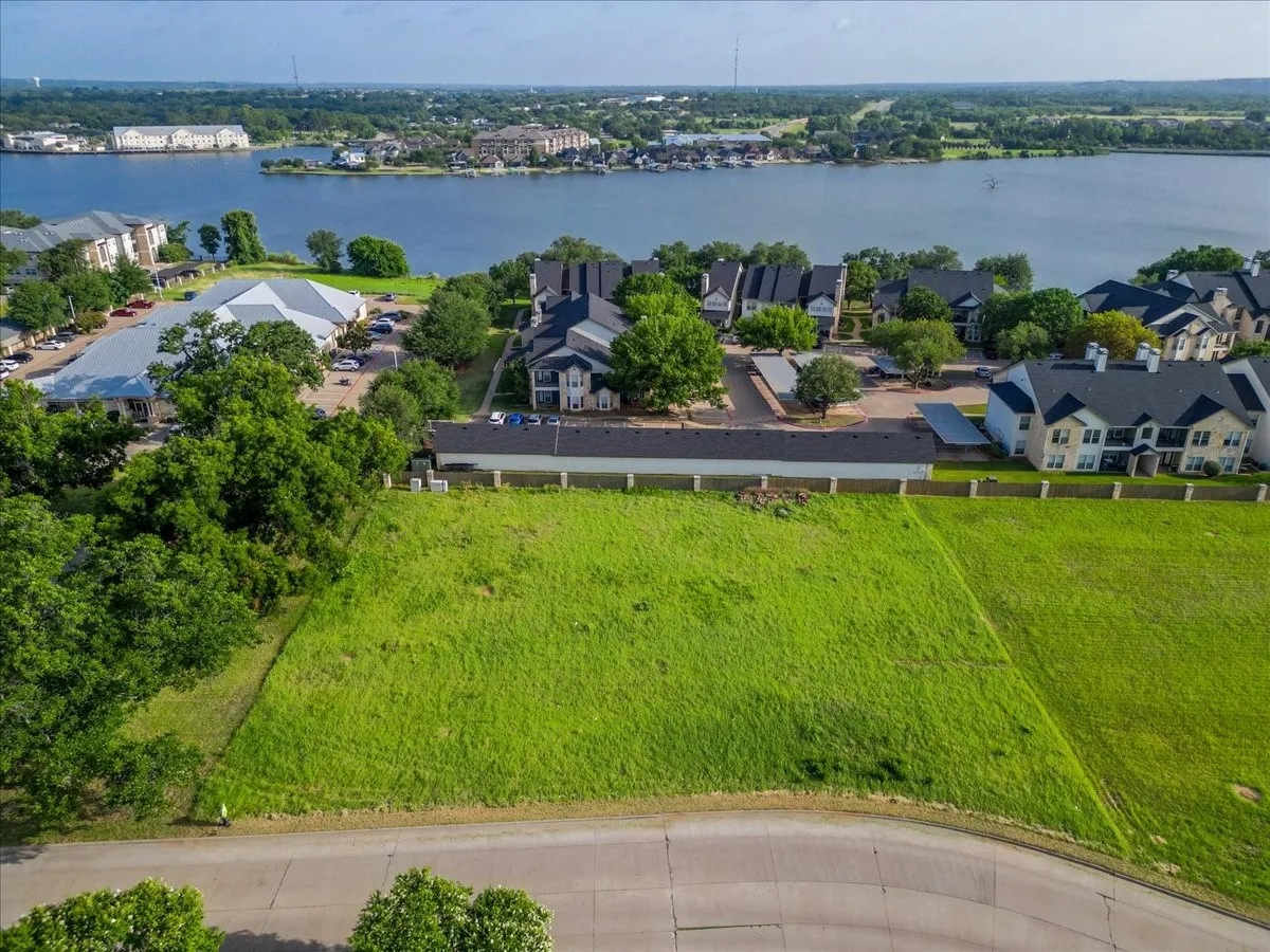 Expansive green lot featuring a paved roadway frontage
