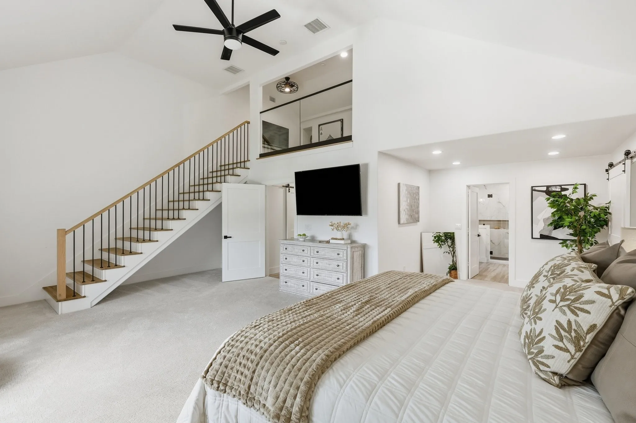 210 Canyon Oaks, Argyle, TX 76226 - Secondary suite with private entrance -Vaulted ceiling bedroom featuring a contemporary staircase with wood treads and black metal balusters, a ceiling fan, recessed lighting, and a barn door leading to an interior space