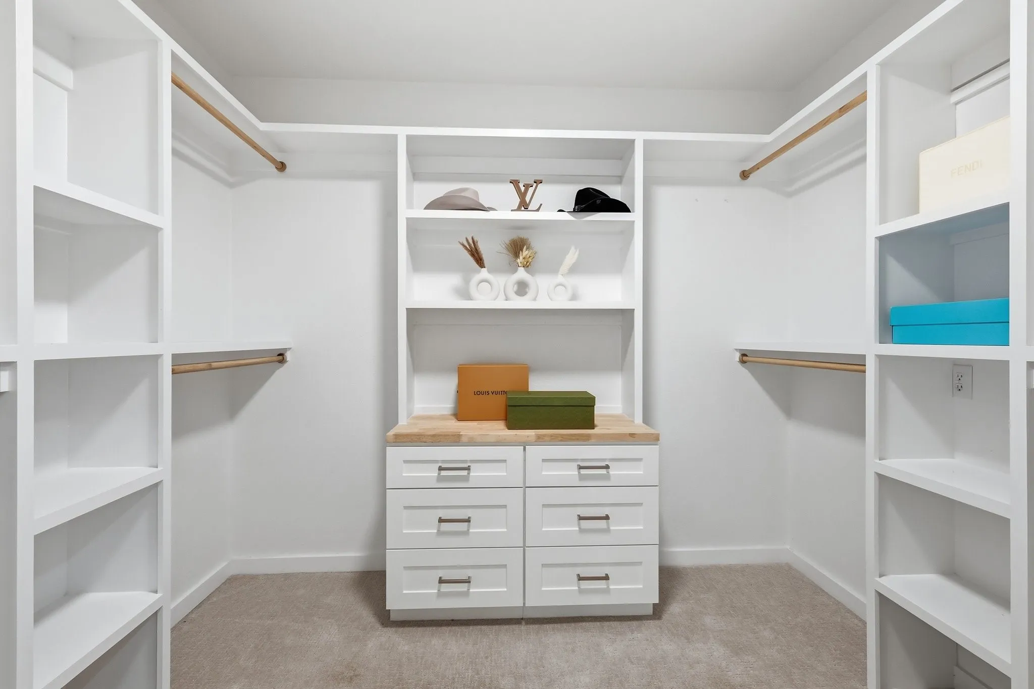 210 Canyon Oaks, Argyle, TX 76226 - First of two primary closests - built-in closet system featuring white shelving, multiple hanging rods, and a central dresser unit