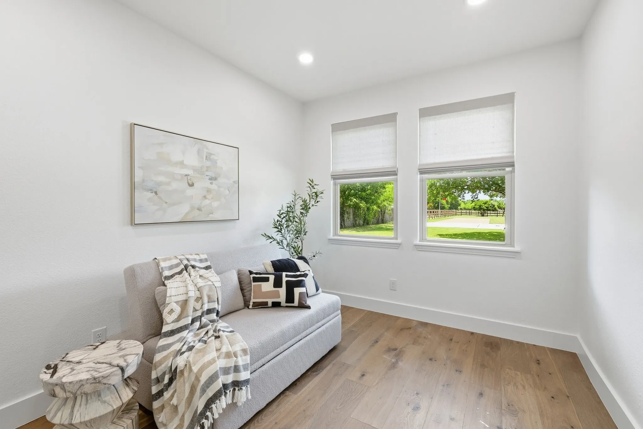 210 Canyon Oaks, Argyle, TX 76226 - Second closet or sitting area in primary bedroom - Bright room featuring two windows with roller shades, recessed lighting, wood-finish flooring, and white walls with modern baseboards