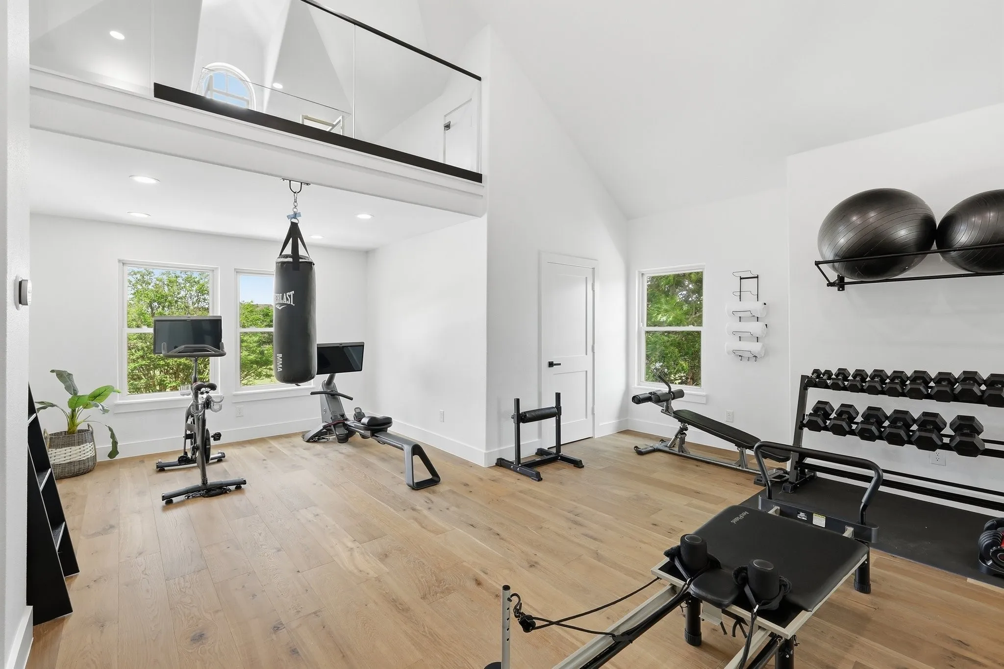 210 Canyon Oaks, Argyle, TX 76226 - Gym or bedroom - Versatile fitness space featuring wood-finish flooring, vaulted ceilings, and a glass-paneled loft with ensuite bathroom. Can be a 6th bedroom.