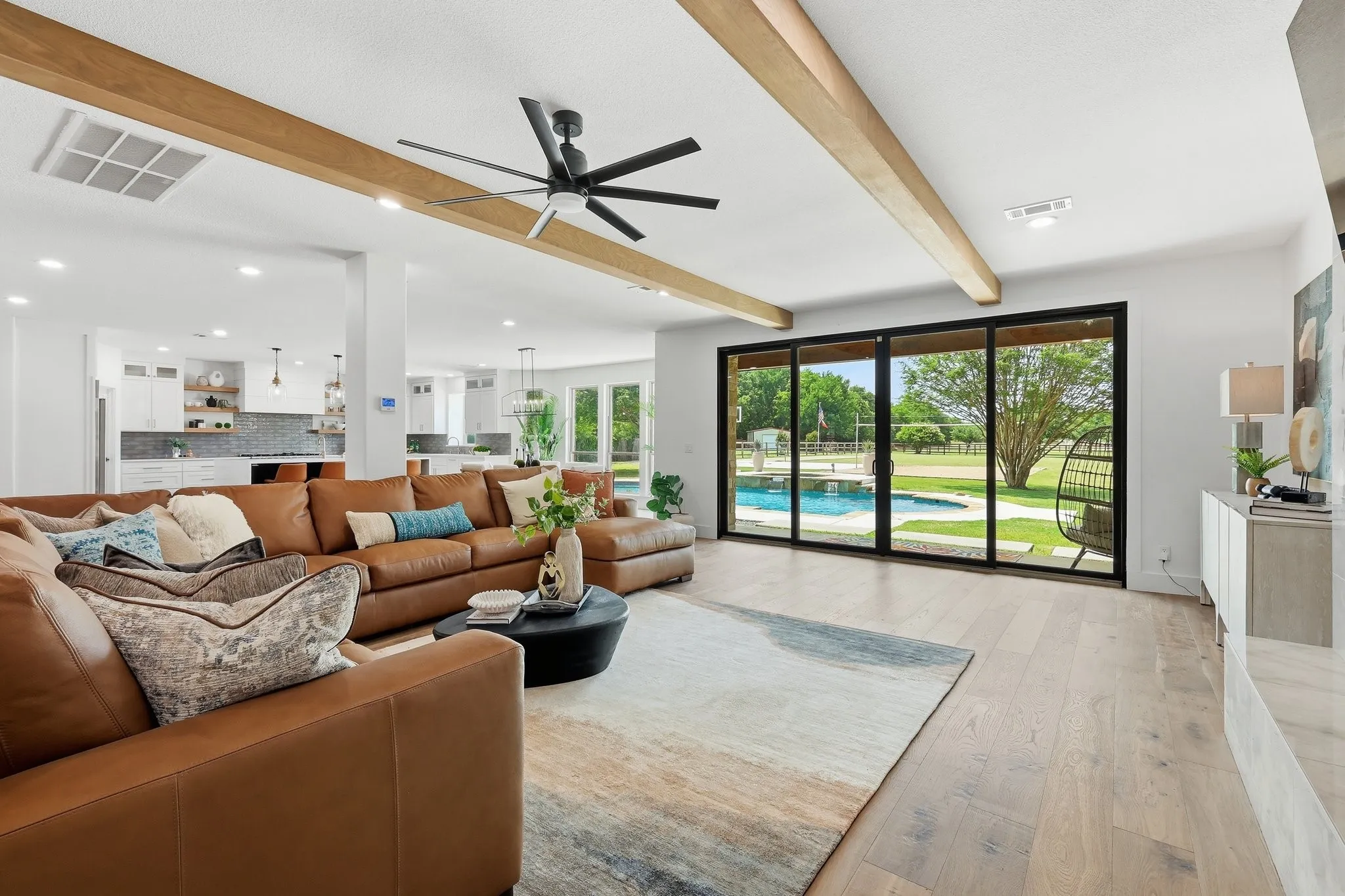 210 Canyon Oaks, Argyle, TX 76226 - Living Room - Spacious interior featuring wood-finish flooring, exposed ceiling beams, and a modern ceiling fan