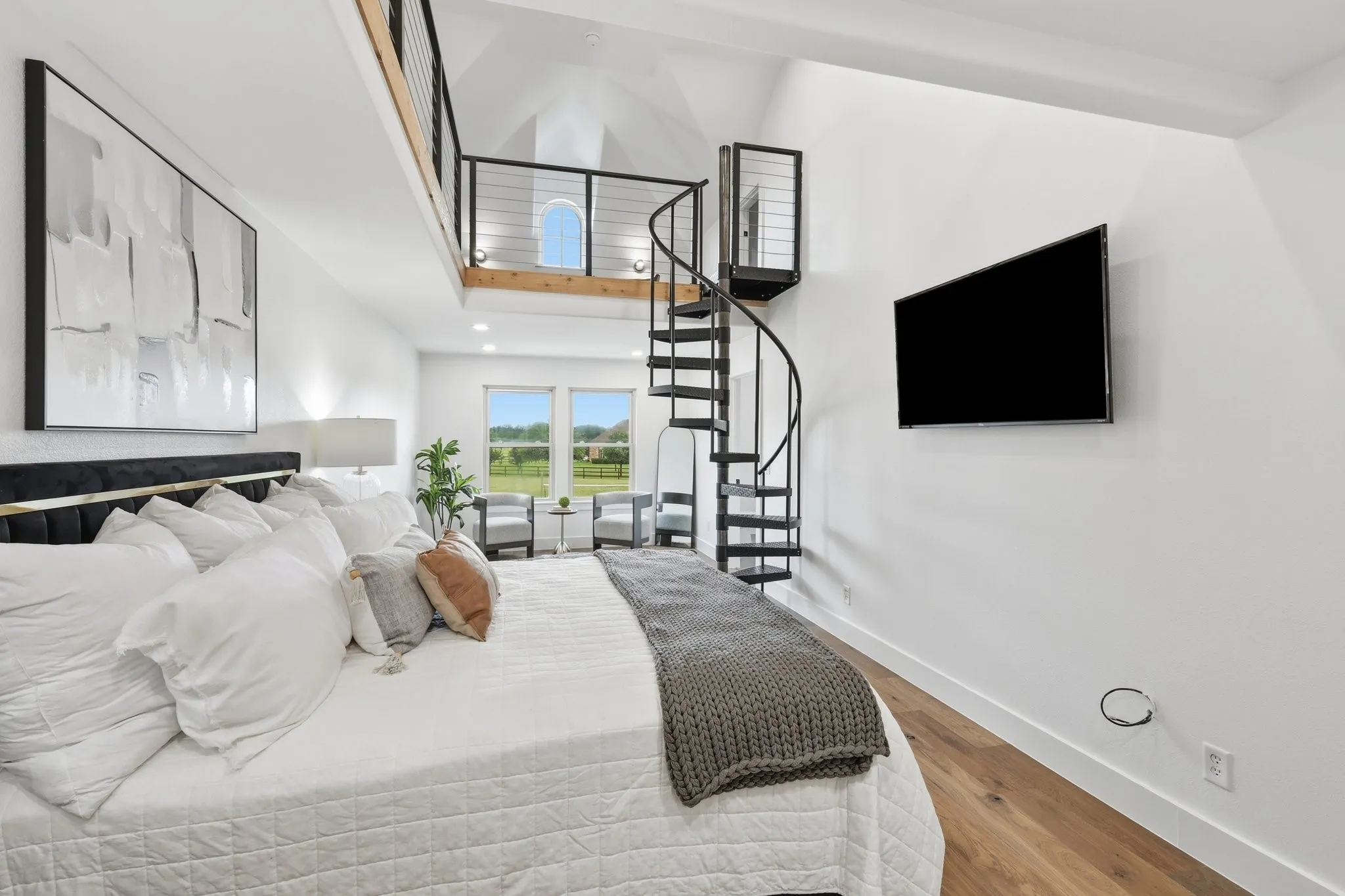 210 Canyon Oaks, Argyle, TX 76226 - Secondary suite with private entrance - Vaulted ceiling bedroom featuring a spiral staircase leading to an upper loft with metal railings and wood-finish flooring