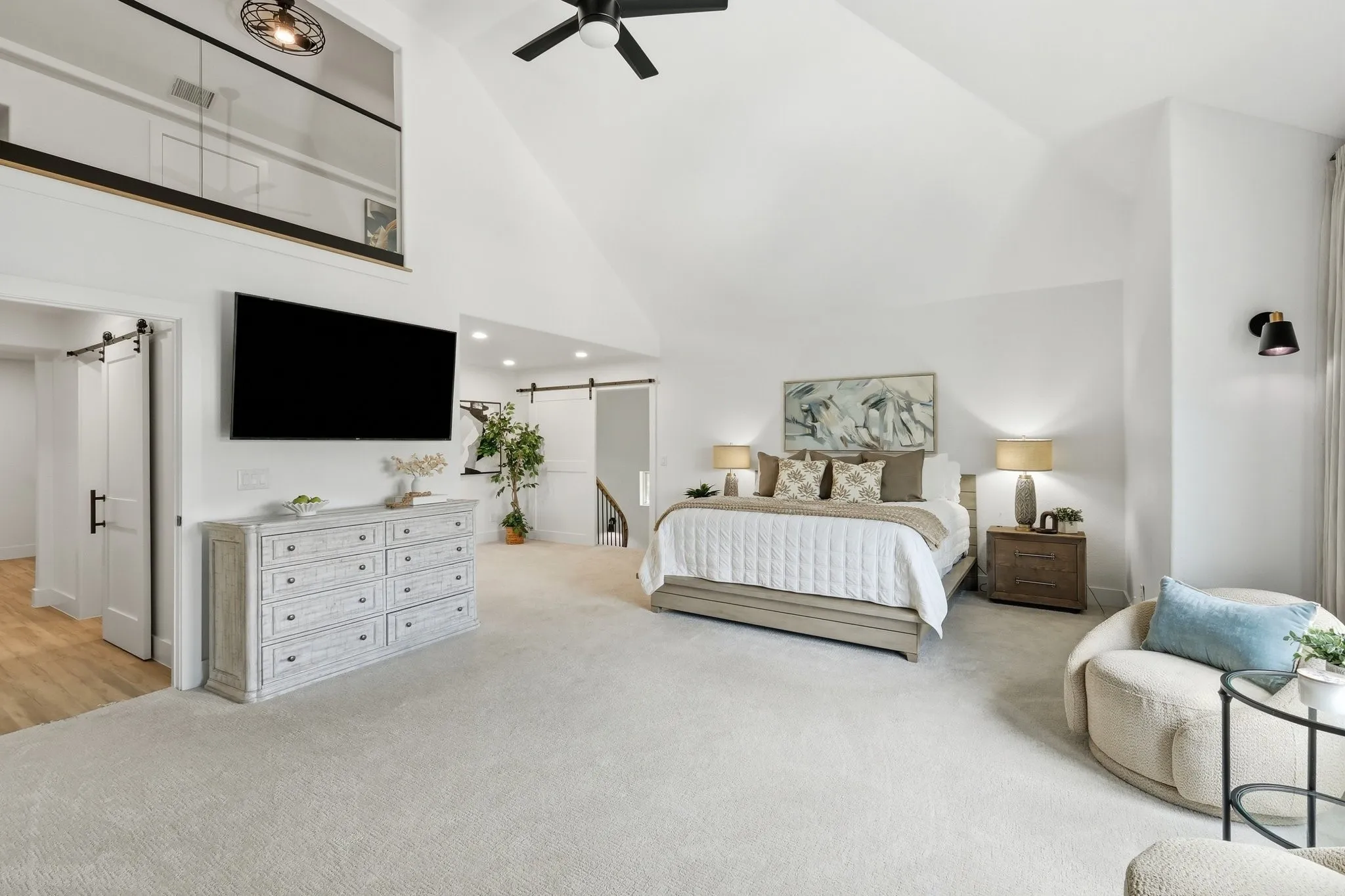 210 Canyon Oaks, Argyle, TX 76226 - Secondary suite with private entrance -Spacious bedroom featuring vaulted ceilings, plush carpeting, a ceiling fan, and black barn doors providing access to internal spaces