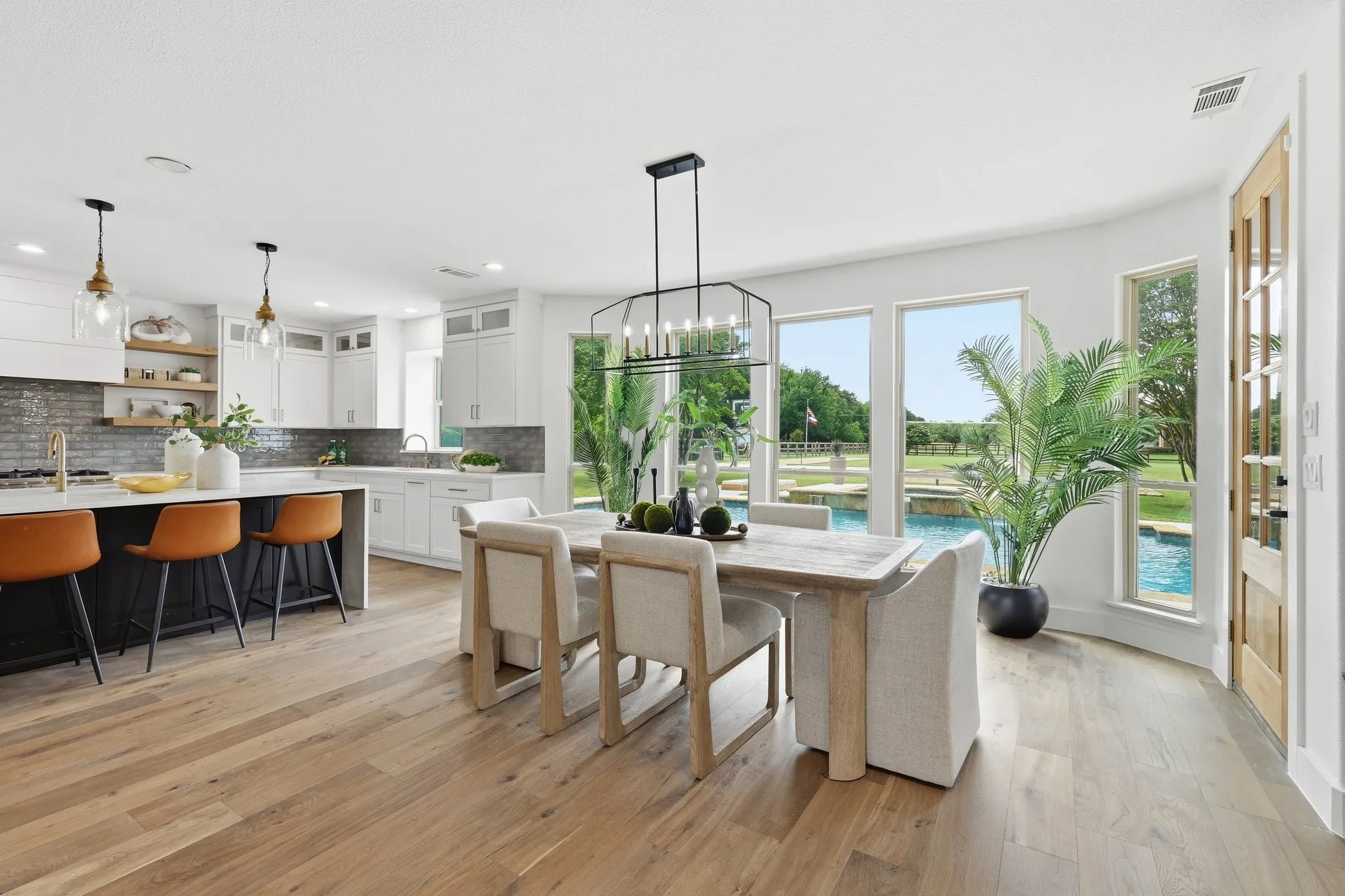 210 Canyon Oaks, Argyle, TX 76226 - Open floor plan with dining area - Open-concept dining area featuring wood-finish flooring, a contemporary chandelier, and expansive windows