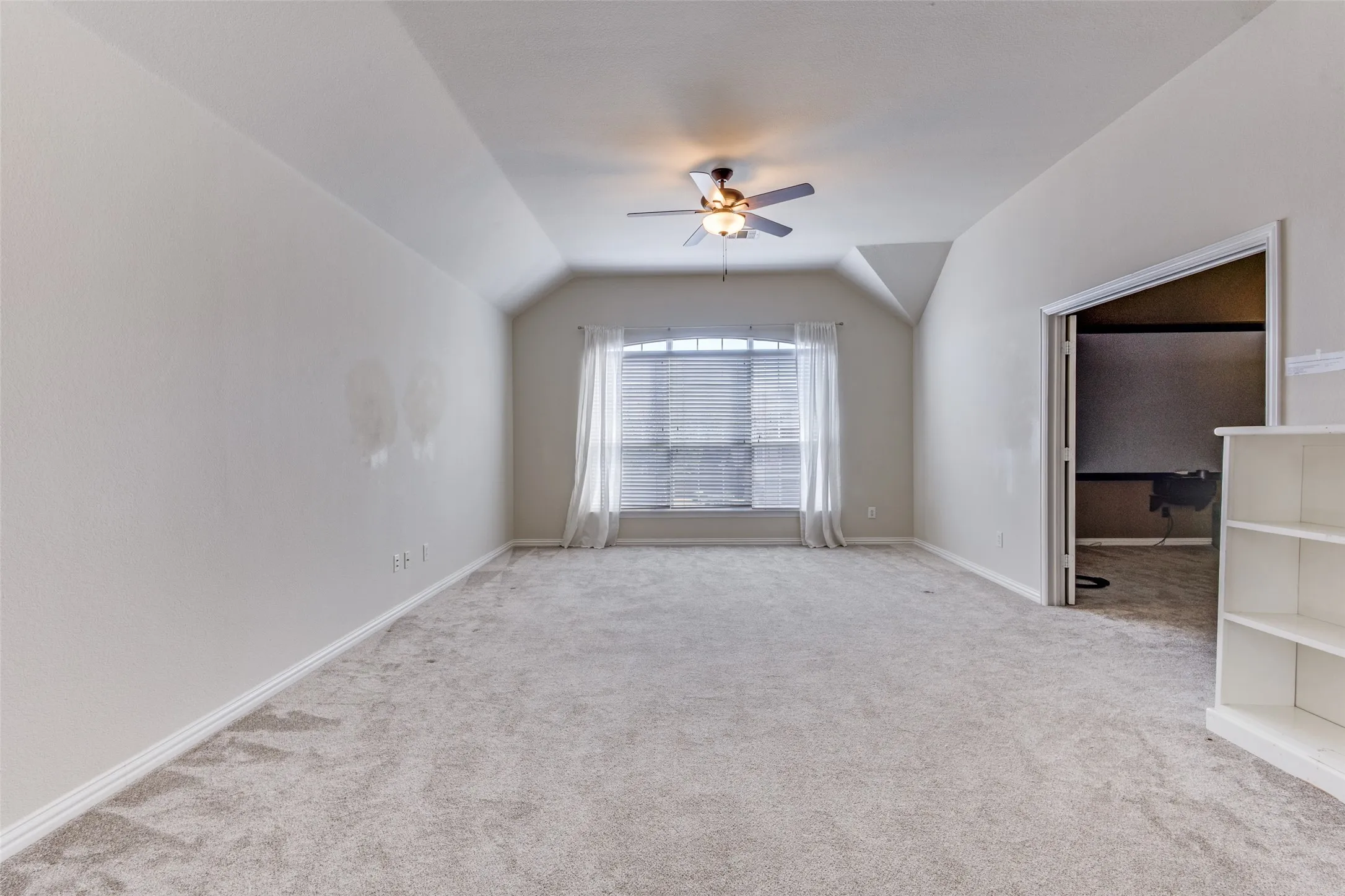 Large game room with carpeted flooring, cinema-style feel, and lofted ceiling, perfectly suited for a second living area, entertainment room, playroom, homework zone, or family gathering space in this spacious McKinney Texas home for sale in the sought-after Virginia Woods community.