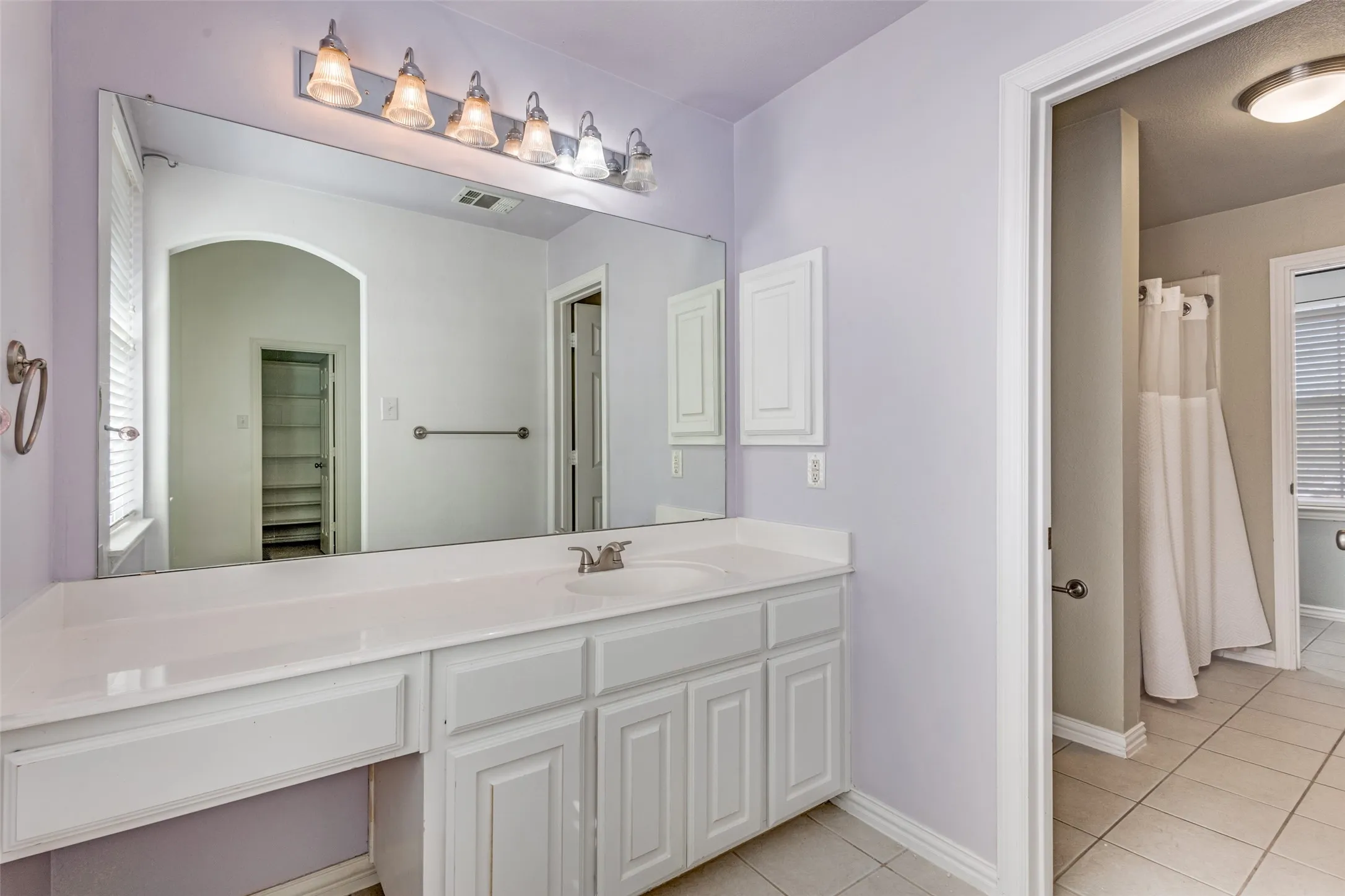 Secondary bathroom with vanity, light tile-patterned flooring, and shower-tub style layout, offering a functional upstairs bath option for family living, guest use, or children’s bedrooms in a desirable Virginia Woods McKinney home for sale near major North Texas destinations and daily conveniences.