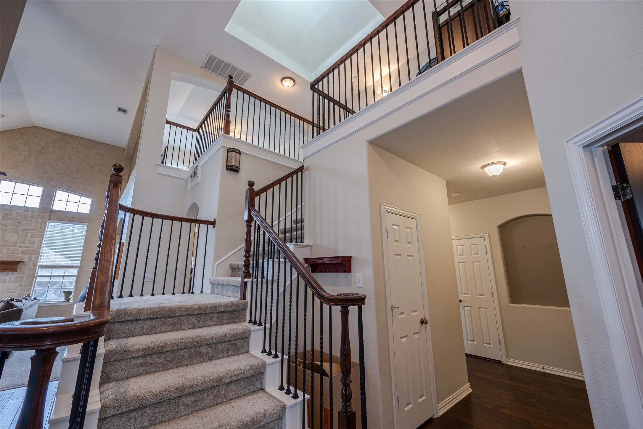 Bright and inviting open living space with carpet flooring, hanging lights, ceiling fan, and high ceiling, offering comfortable everyday living, flexible furniture placement, and a warm family-friendly atmosphere in this traditional Virginia Woods McKinney home for sale in one of North Texas’s most desirable suburban communities.