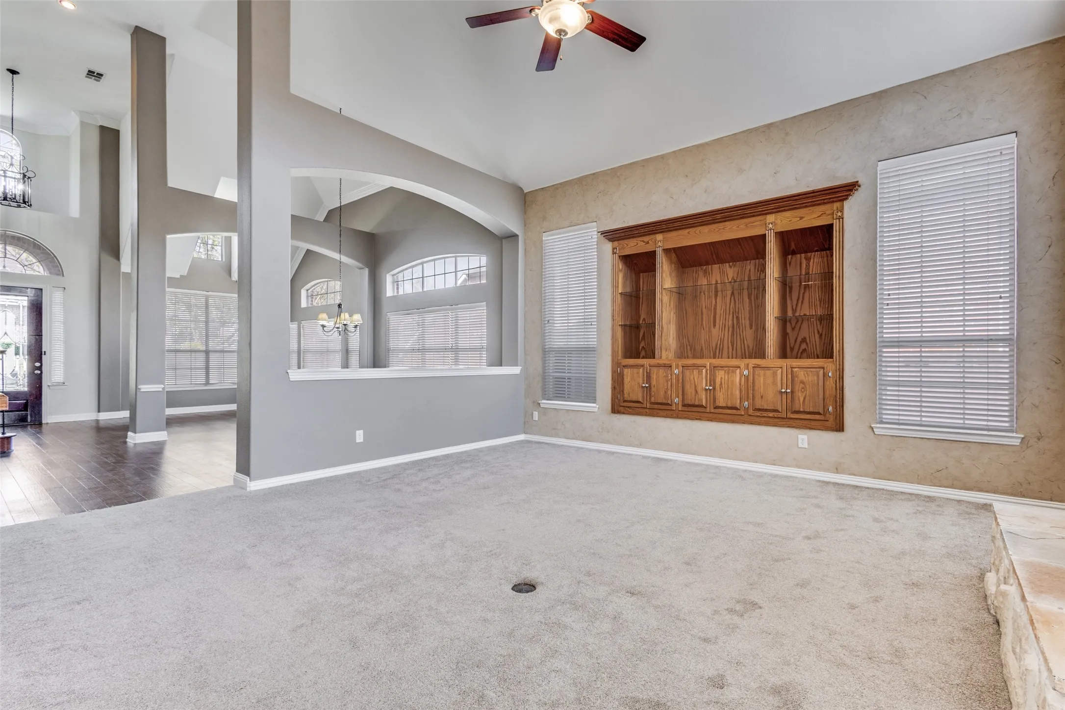 Bright and inviting open living space with carpet flooring, hanging lights, ceiling fan, and high ceiling, offering comfortable everyday living, flexible furniture placement, and a warm family-friendly atmosphere in this traditional Virginia Woods McKinney home for sale in one of North Texas’s most desirable suburban communities.