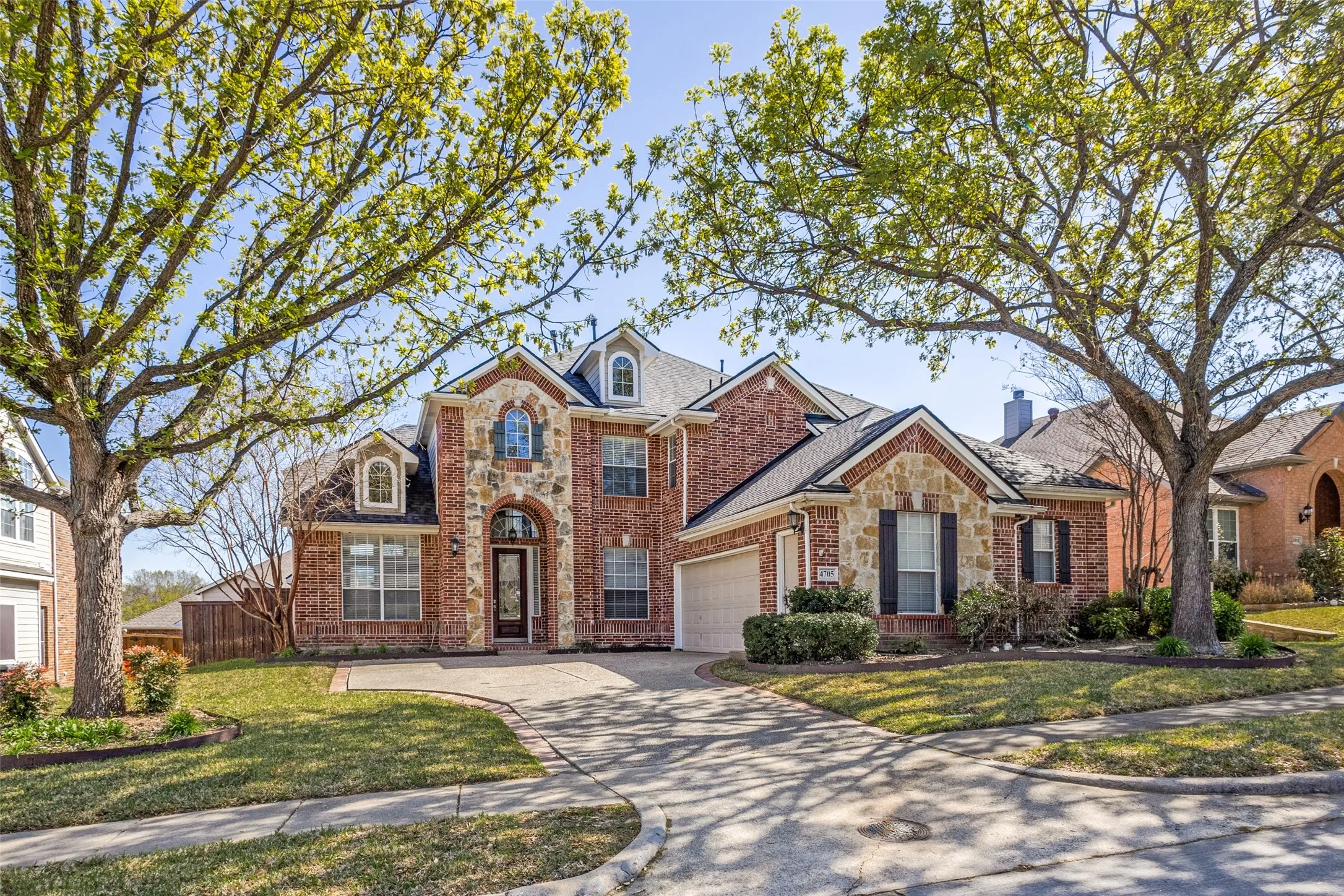 Traditional McKinney home with stone siding, brick siding, front lawn, driveway, and attached garage, located in the sought-after Virginia Woods subdivision and offering the ideal combination of curb appeal, neighborhood charm, and convenient access to McKinney ISD schools, shopping, dining, and North Texas commuter routes.