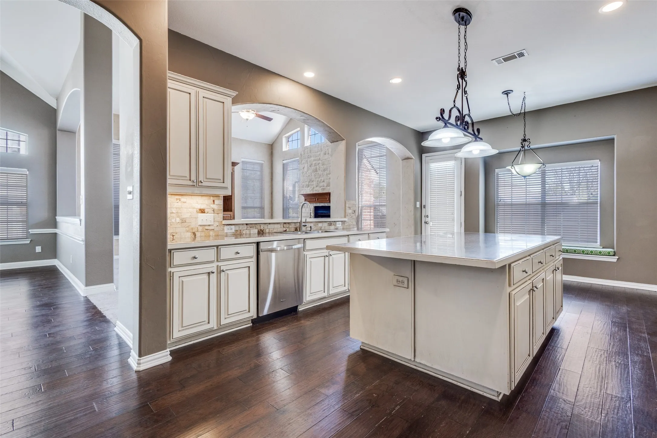 Spacious gourmet kitchen featuring stainless steel dishwasher, decorative backsplash, center island, pendant lighting, ample counter space, and excellent flow for family meals and entertaining, making this McKinney TX home especially attractive to buyers searching for a luxury kitchen, open-concept living, and a desirable home in McKinney ISD and Collin County.