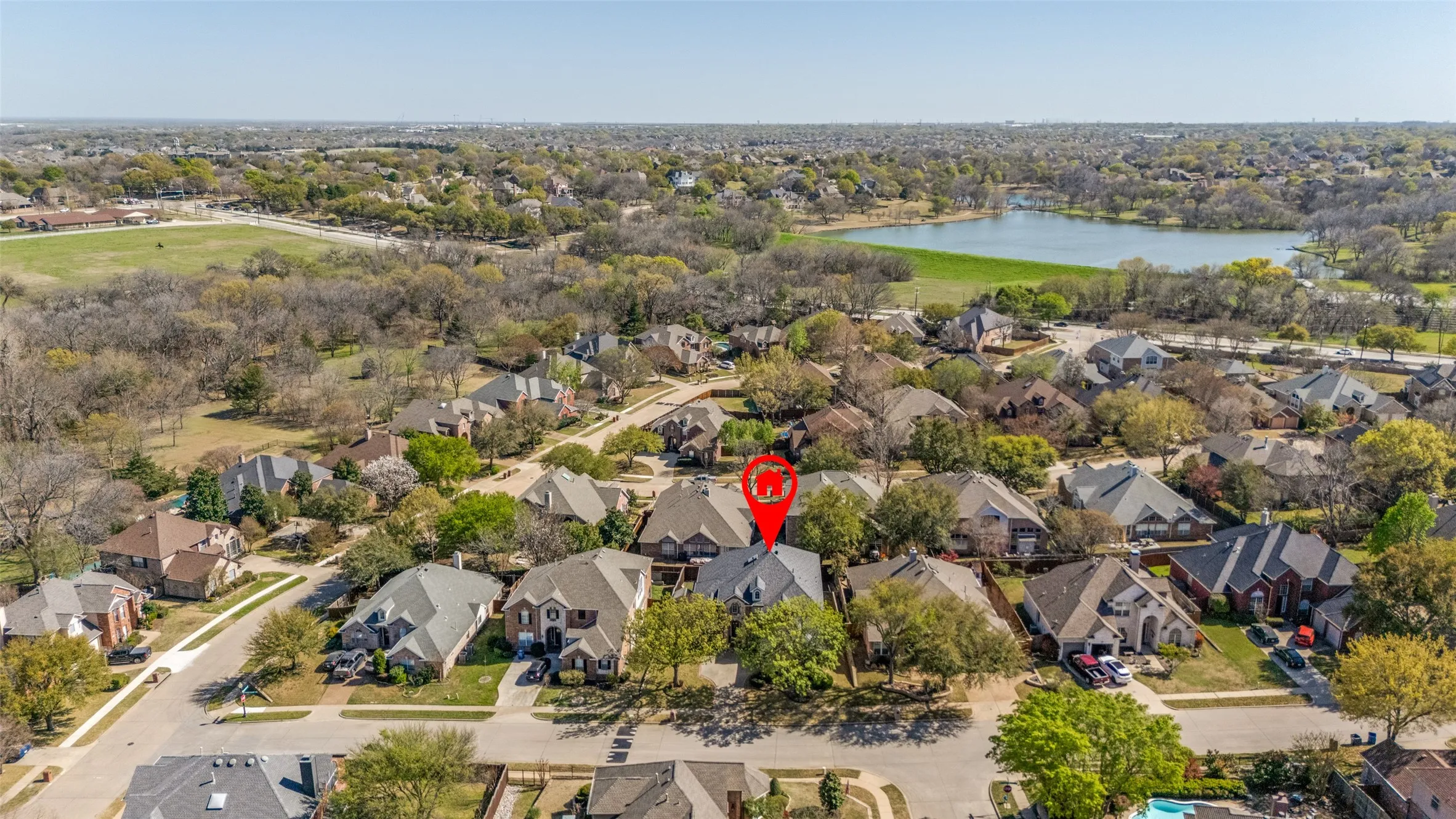 Aerial overview of the property location with nearby water feature, surrounding suburban landscape, and North Texas neighborhood context, adding search value for buyers looking for a McKinney home for sale in a peaceful established community with access to city conveniences and commuter highways.