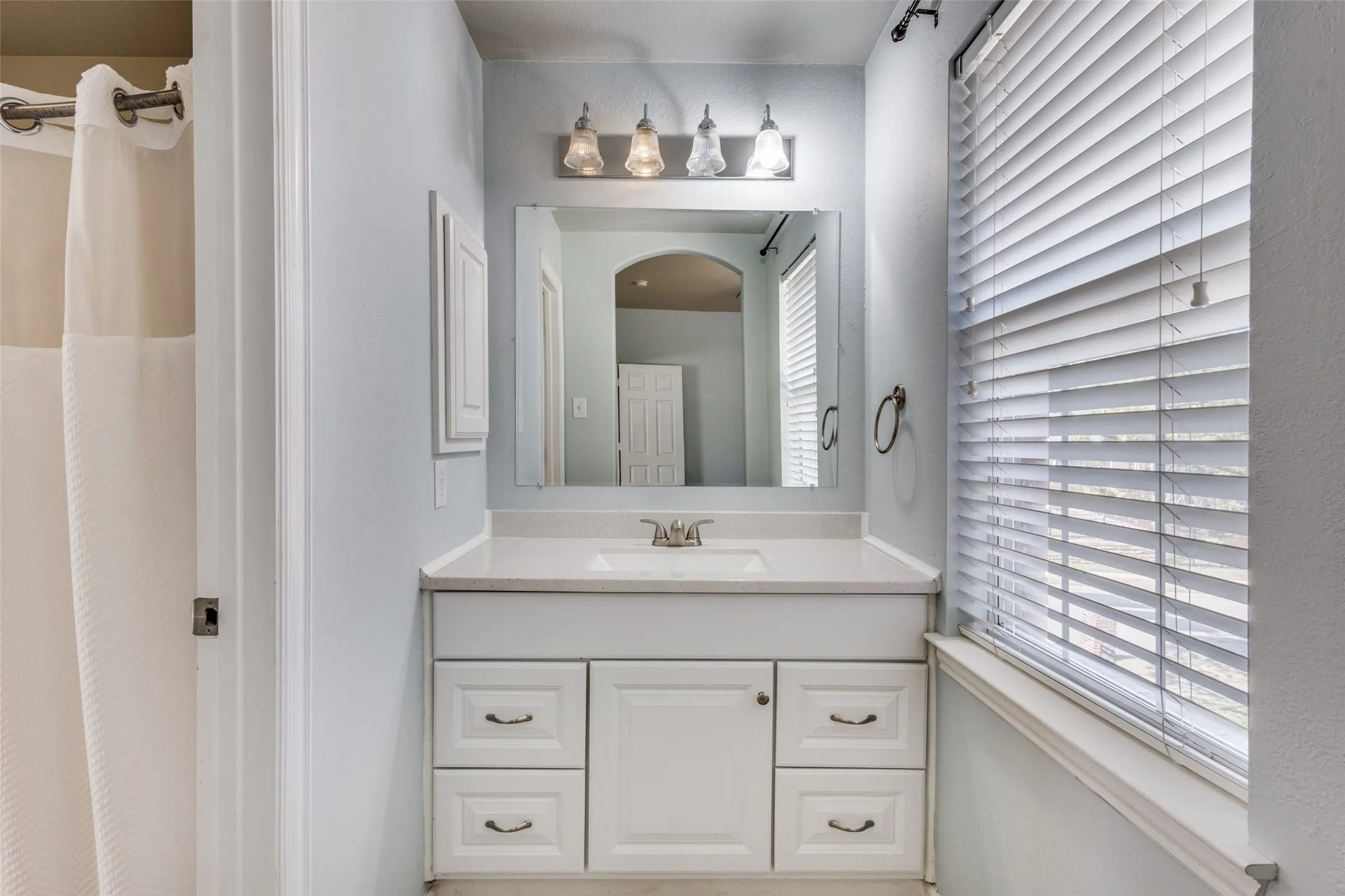 Full bathroom with vanity and shower with curtain, providing practical everyday function, convenient access from secondary bedrooms, and valuable household flexibility in this traditional McKinney Texas home located in Collin County and served by McKinney ISD.